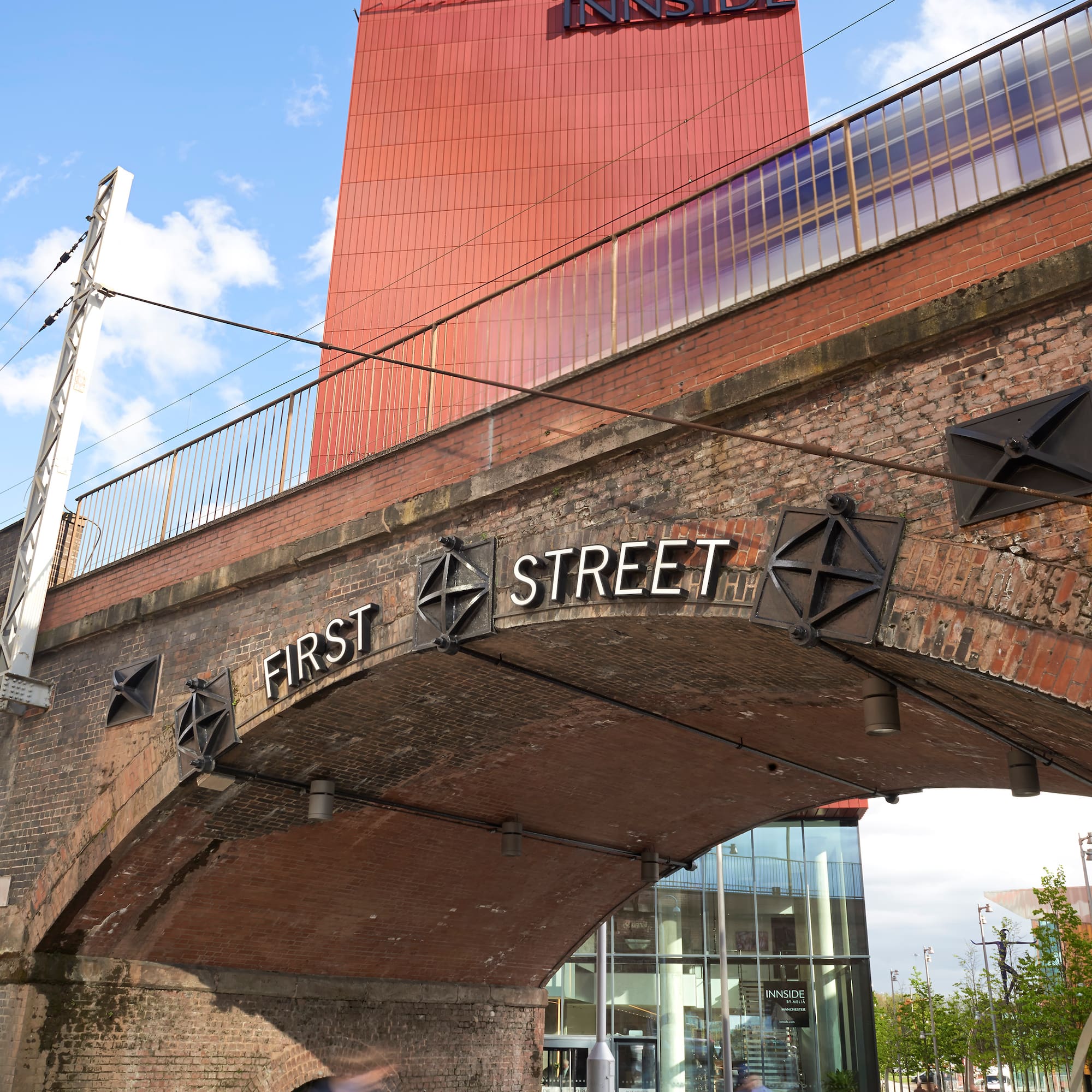 Red Innside Hotel above historic First Street brick archway, Manchester.