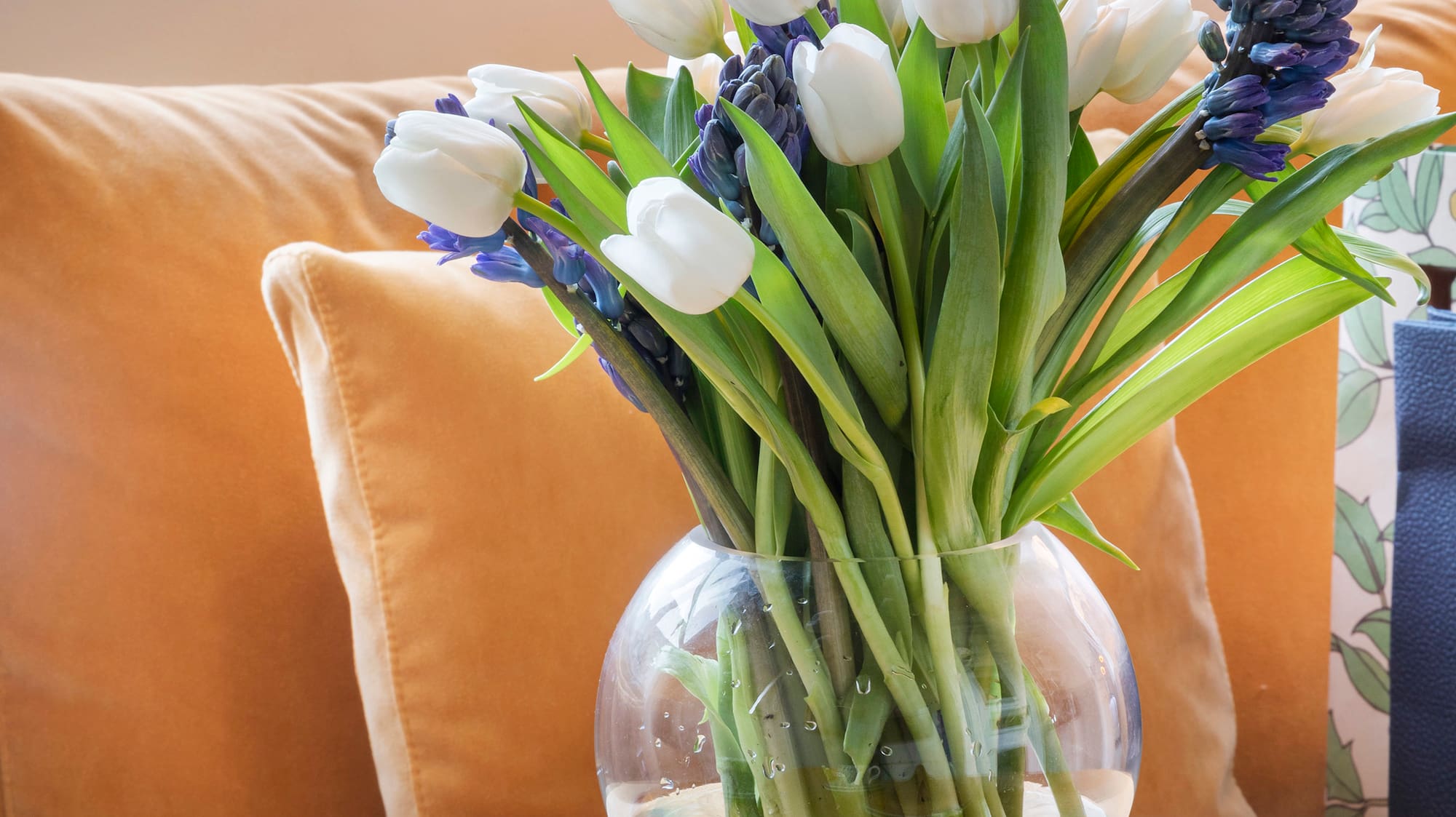 a vase of flowers and desserts on a table