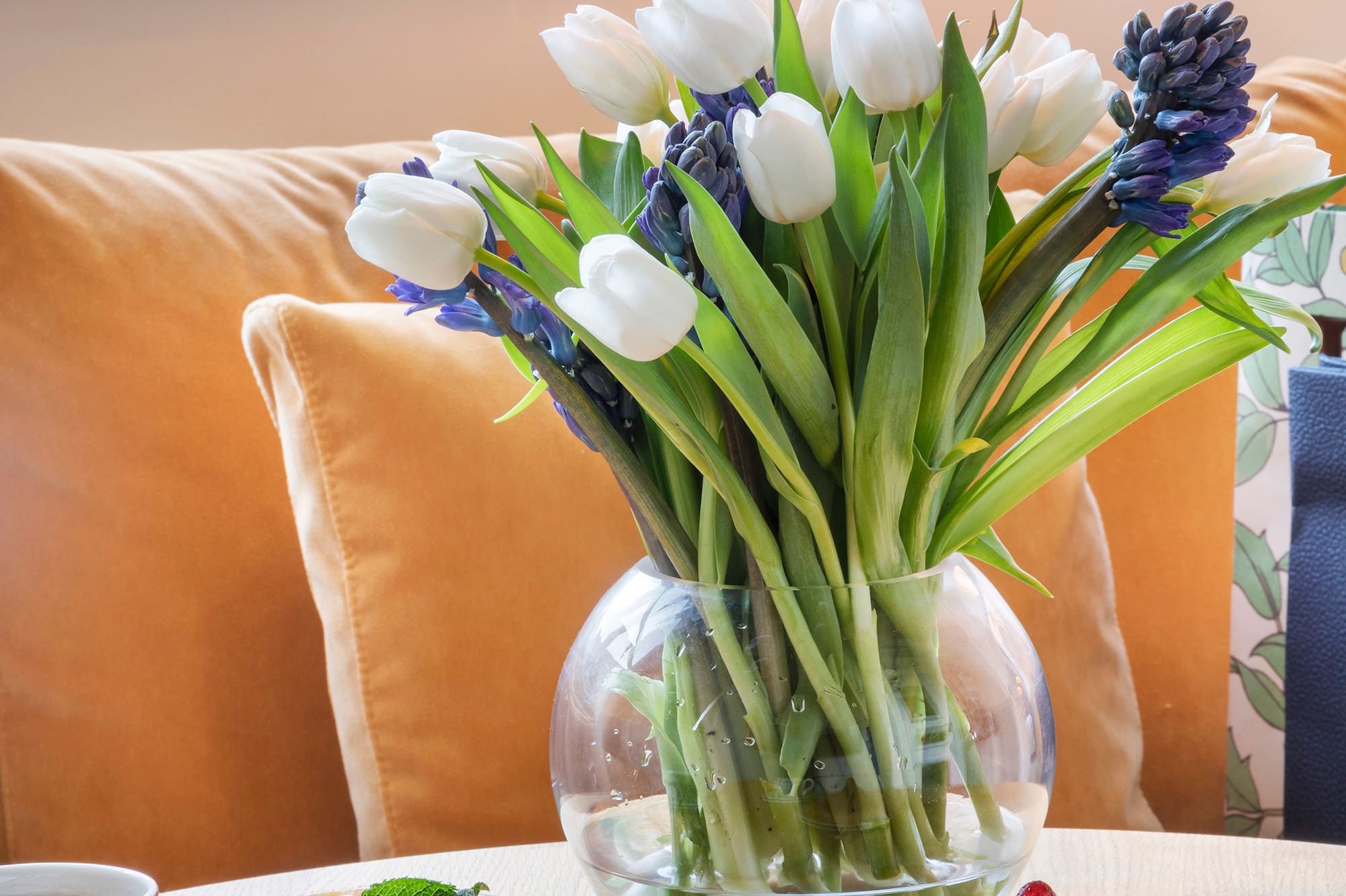 a vase of flowers and desserts on a table
