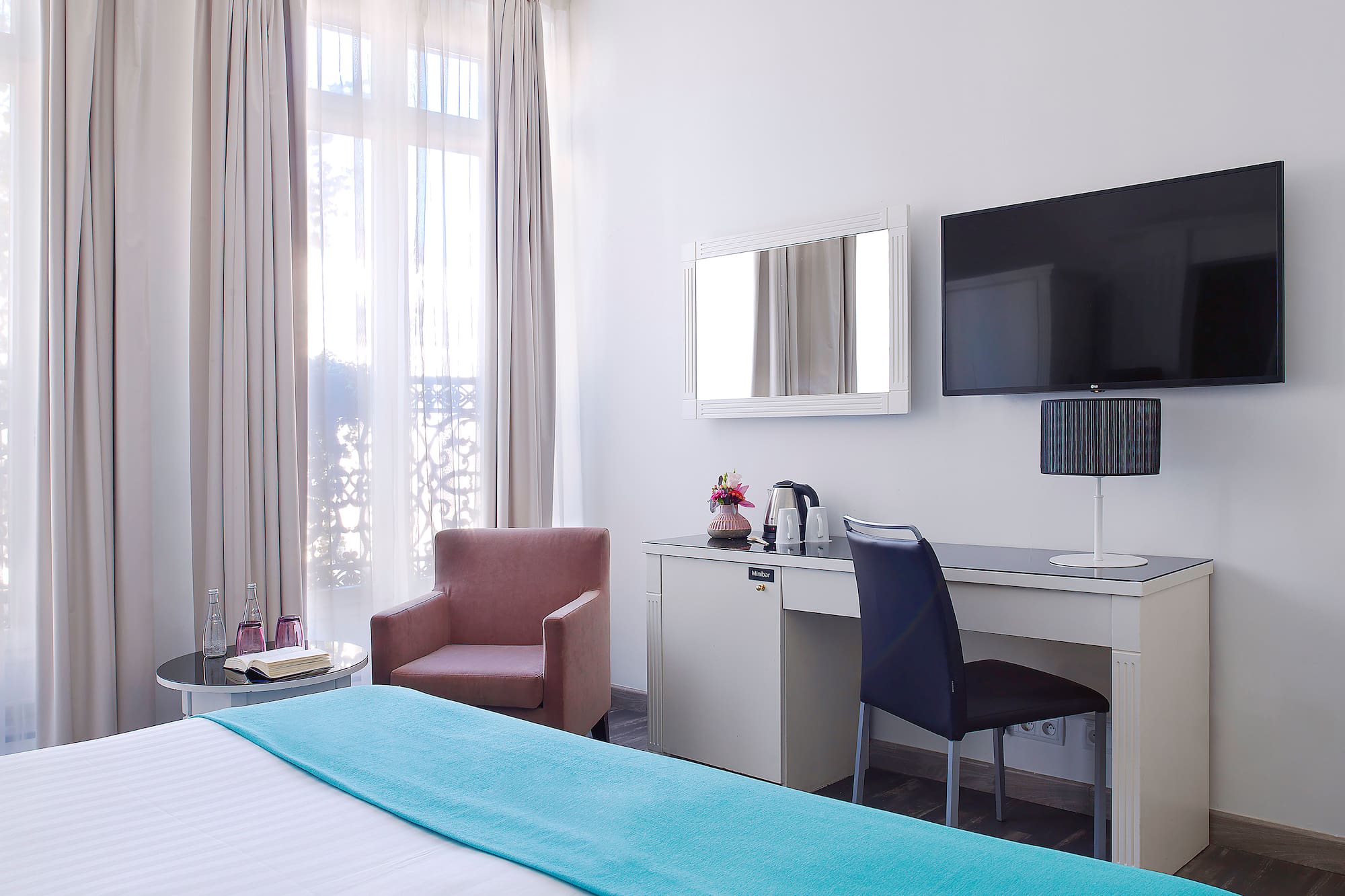 a room with a bed and a chair and a television