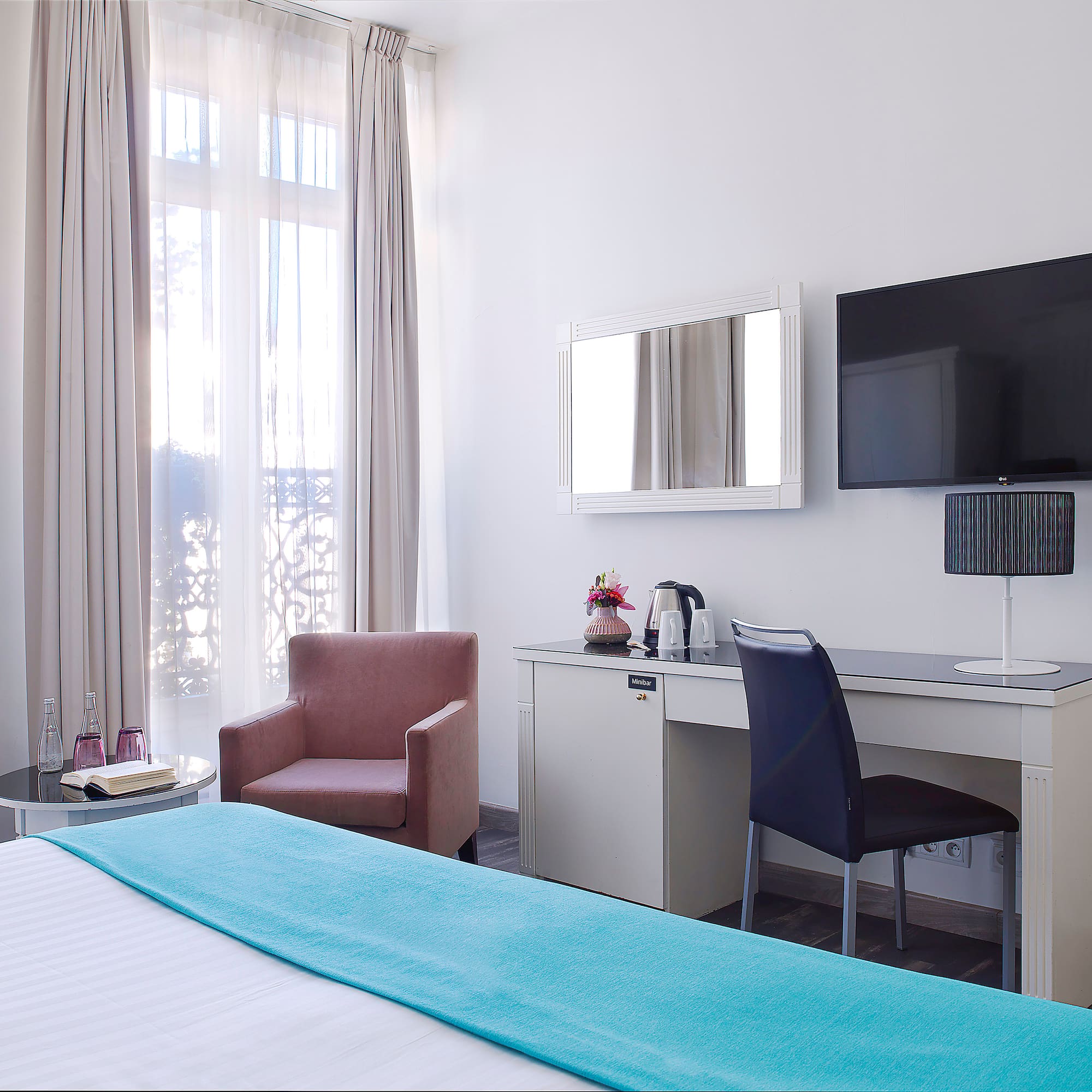 a room with a bed and a chair and a television