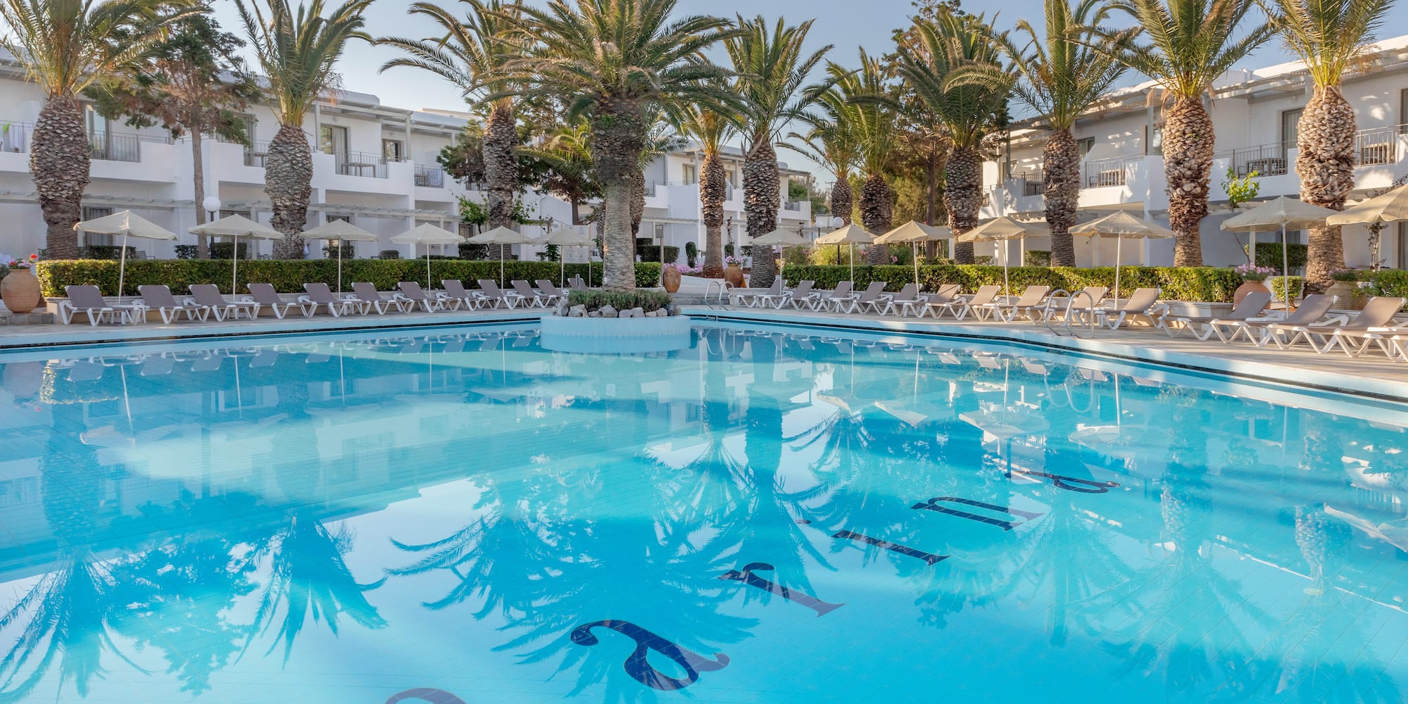 a pool with palm trees and buildings