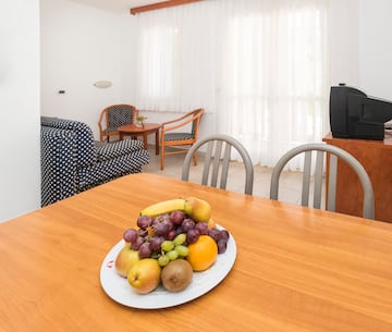 a plate of fruit on a table in a room with chairs and a television