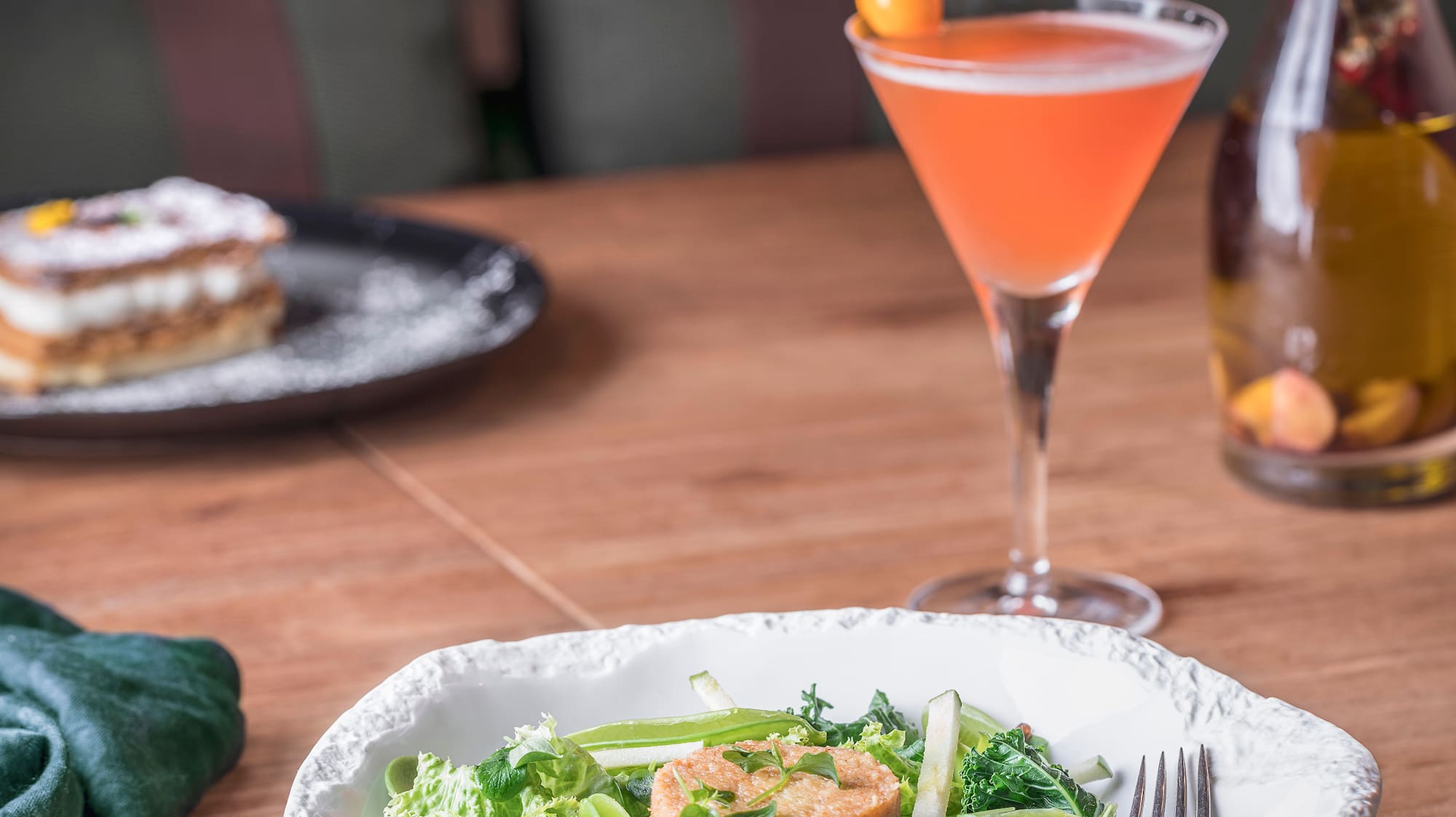 a bowl of salad and a drink on a table