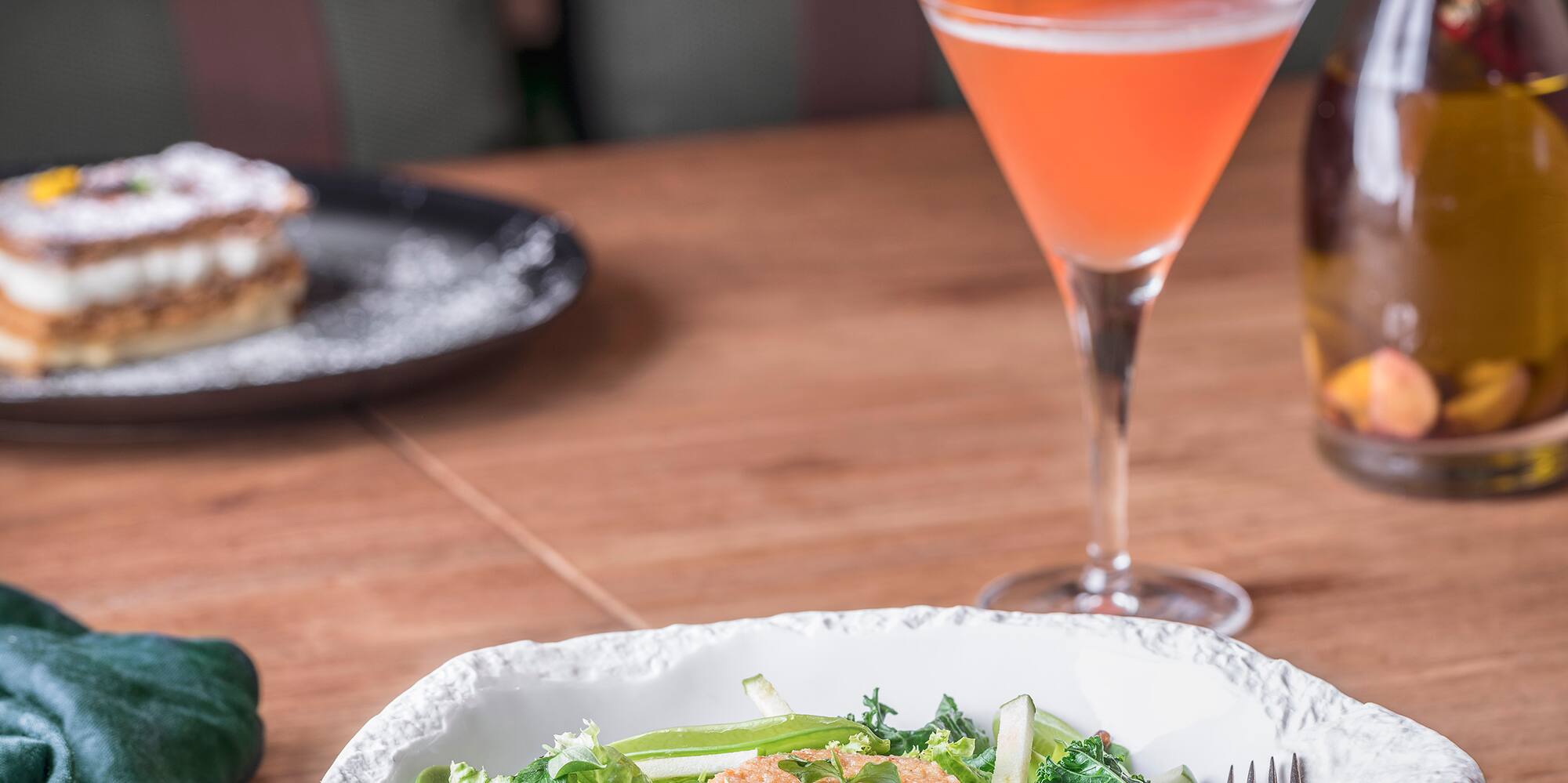 a bowl of salad and a drink on a table