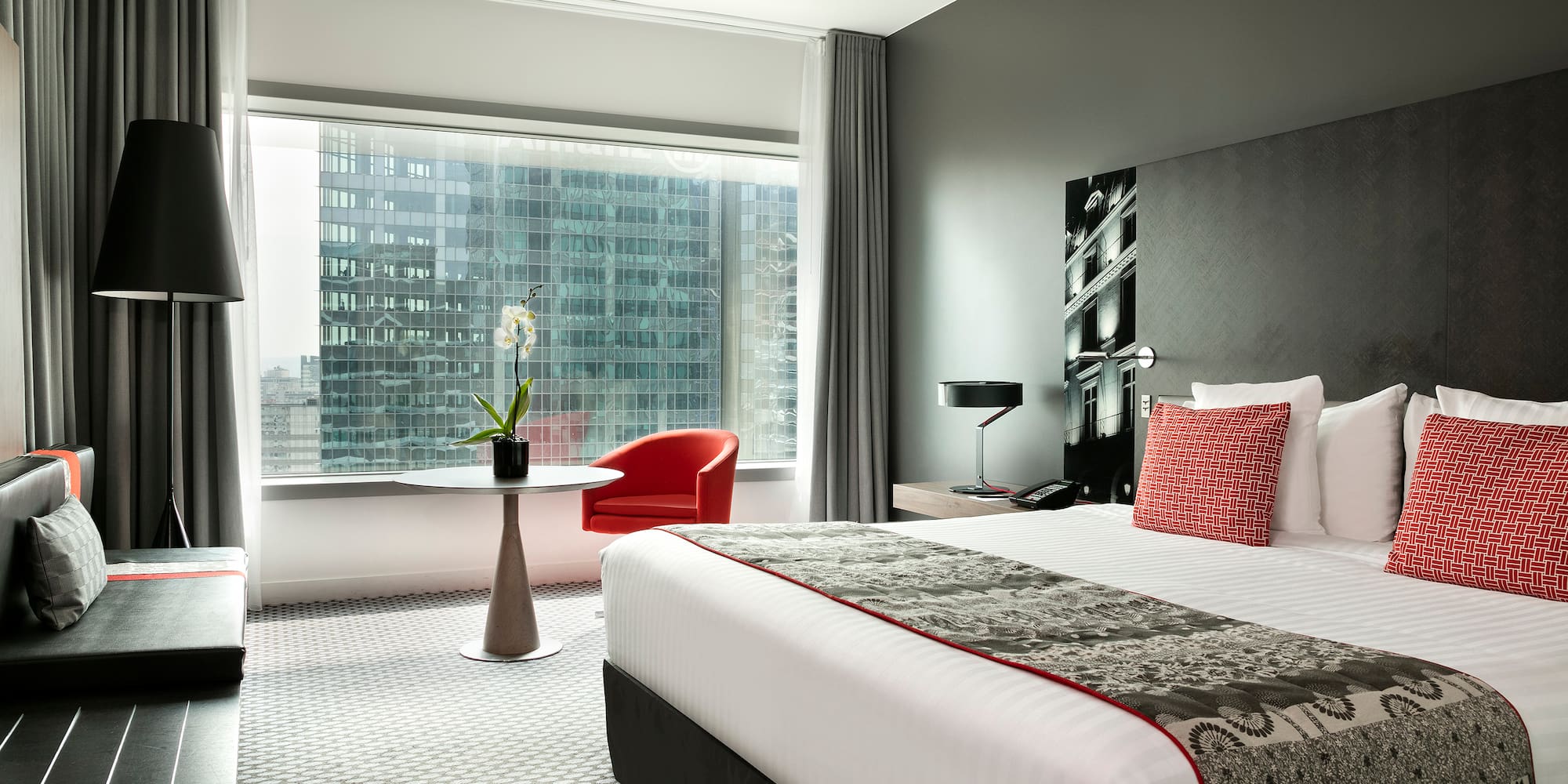 a bedroom with a large window and a bed