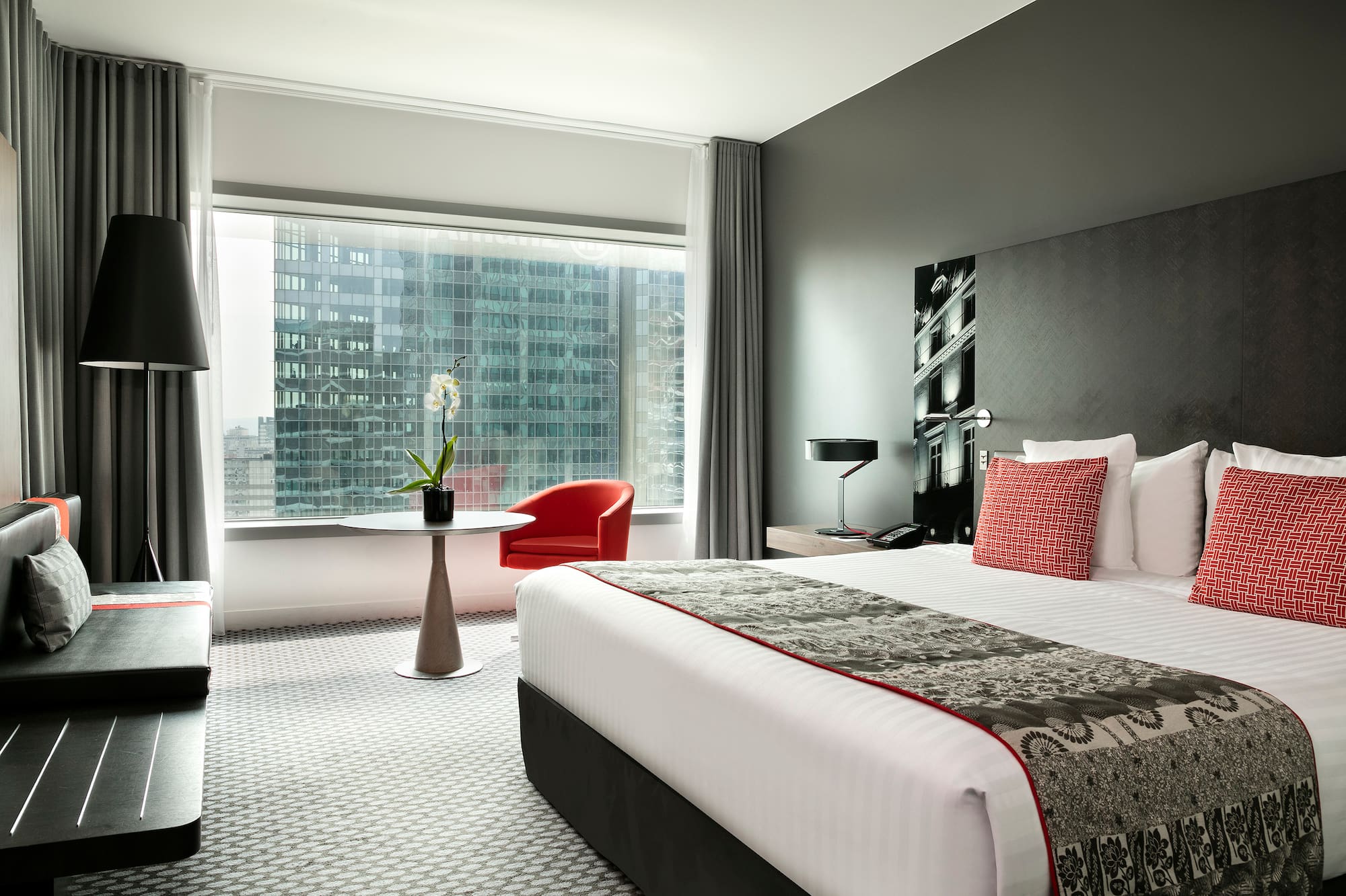 a bedroom with a large window and a bed