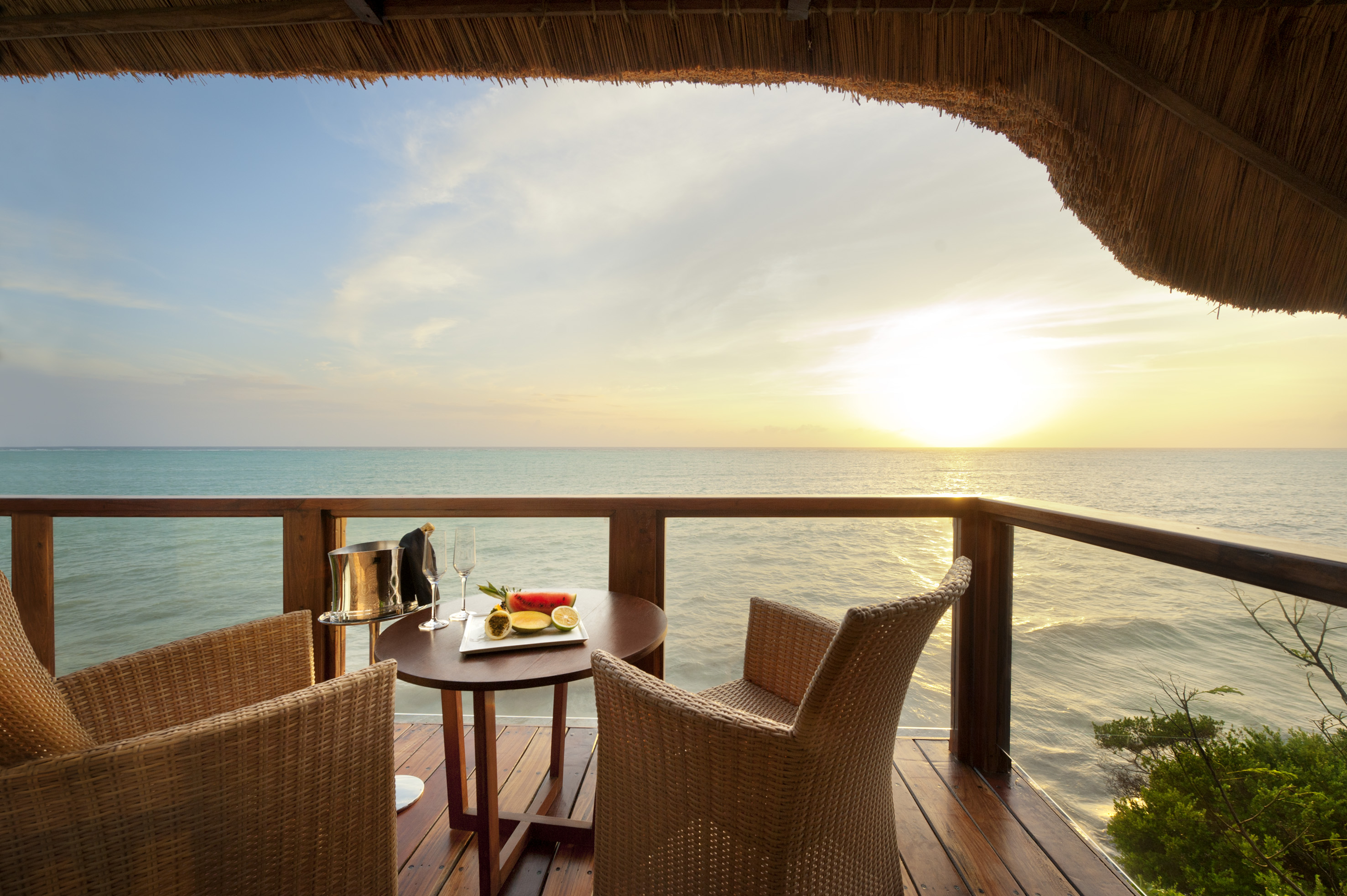 a table and chairs on a deck overlooking the ocean