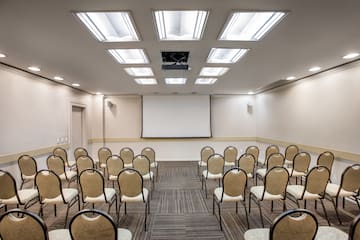 a room with many chairs and a projector screen