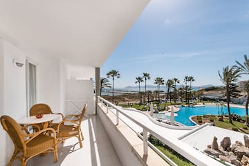 a balcony with a table and chairs and a pool