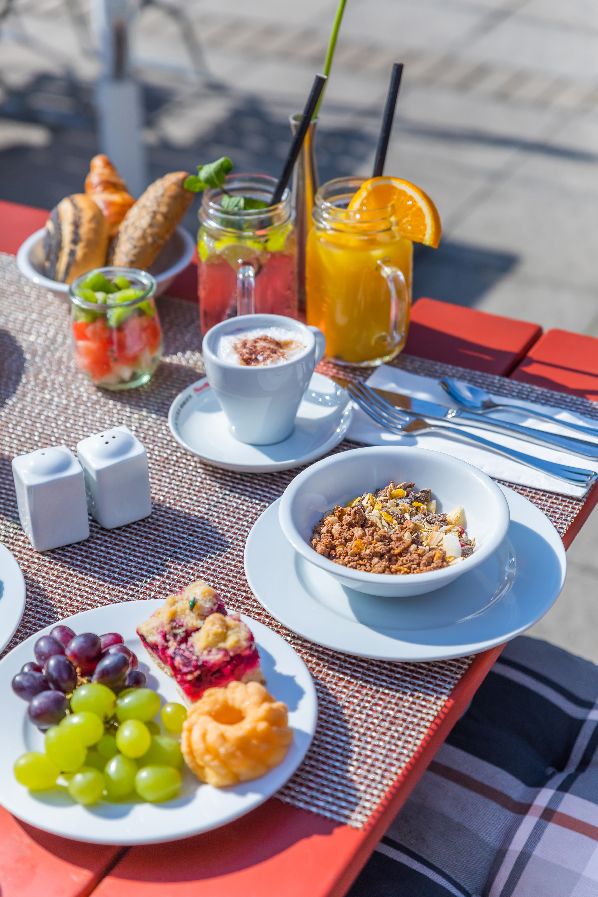 Delicious outdoor breakfast with pastries, muesli, fresh fruit, coffee, and juices.