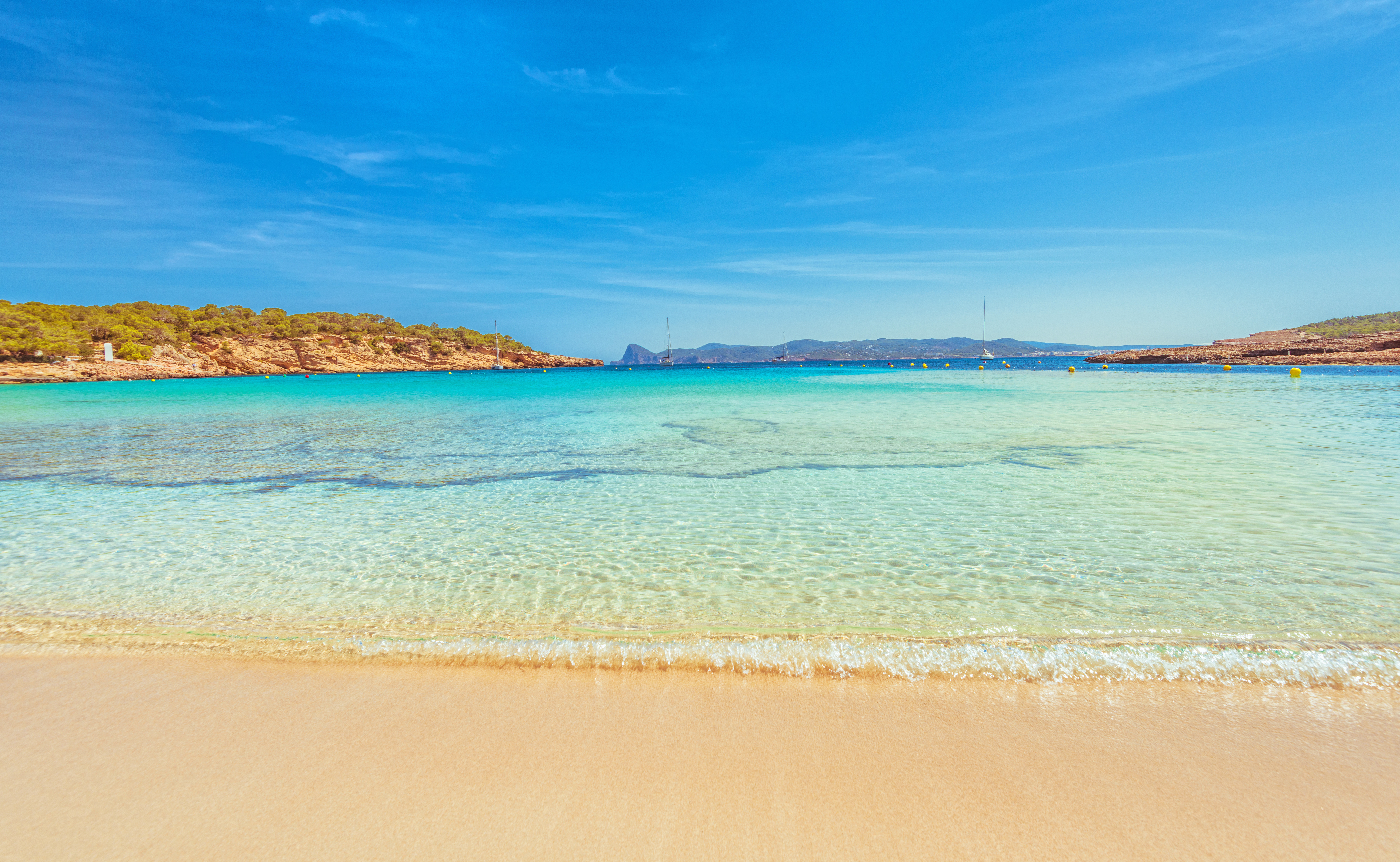 a beach with clear water and blue sky