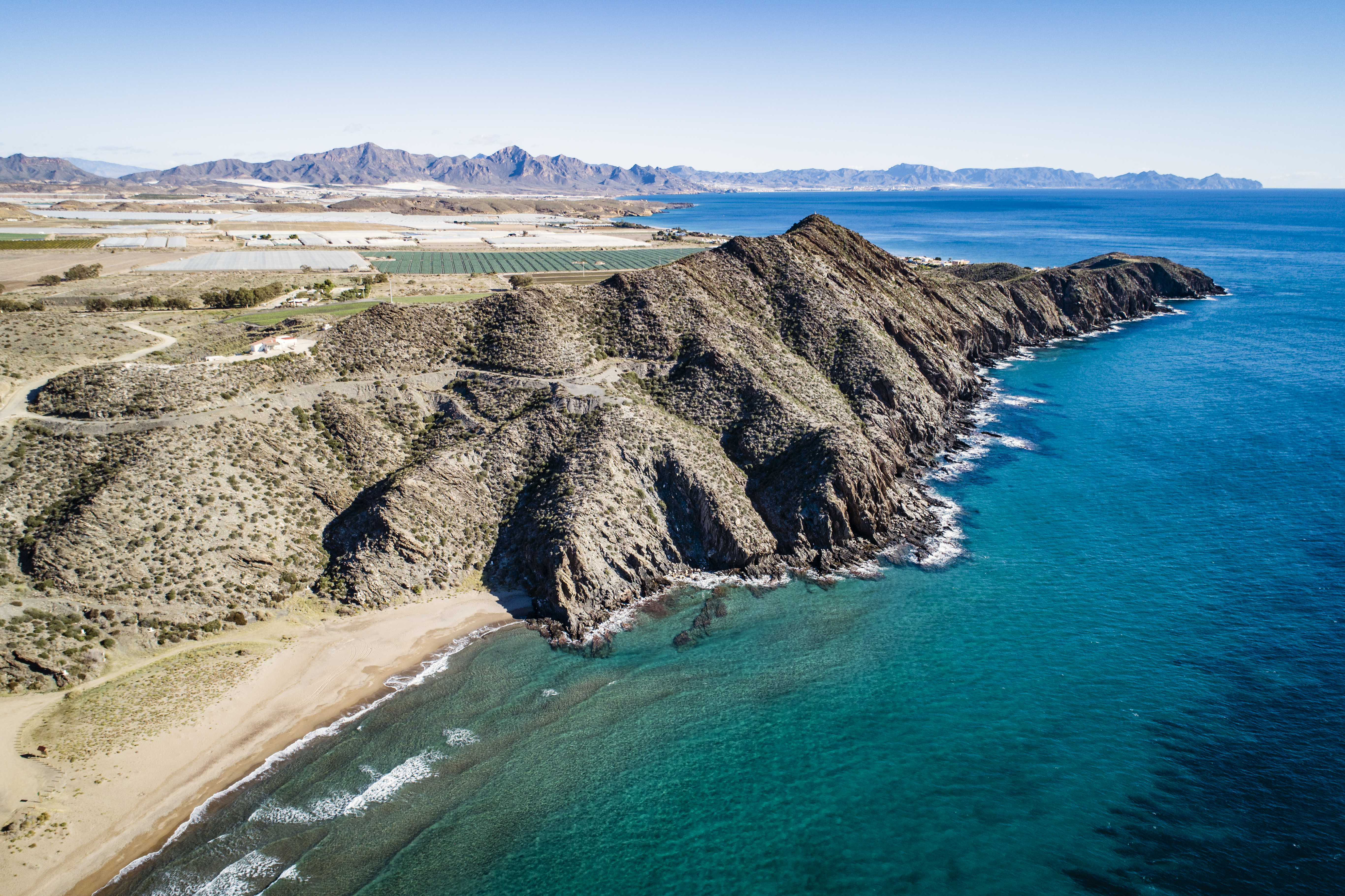 a rocky cliff next to a body of water