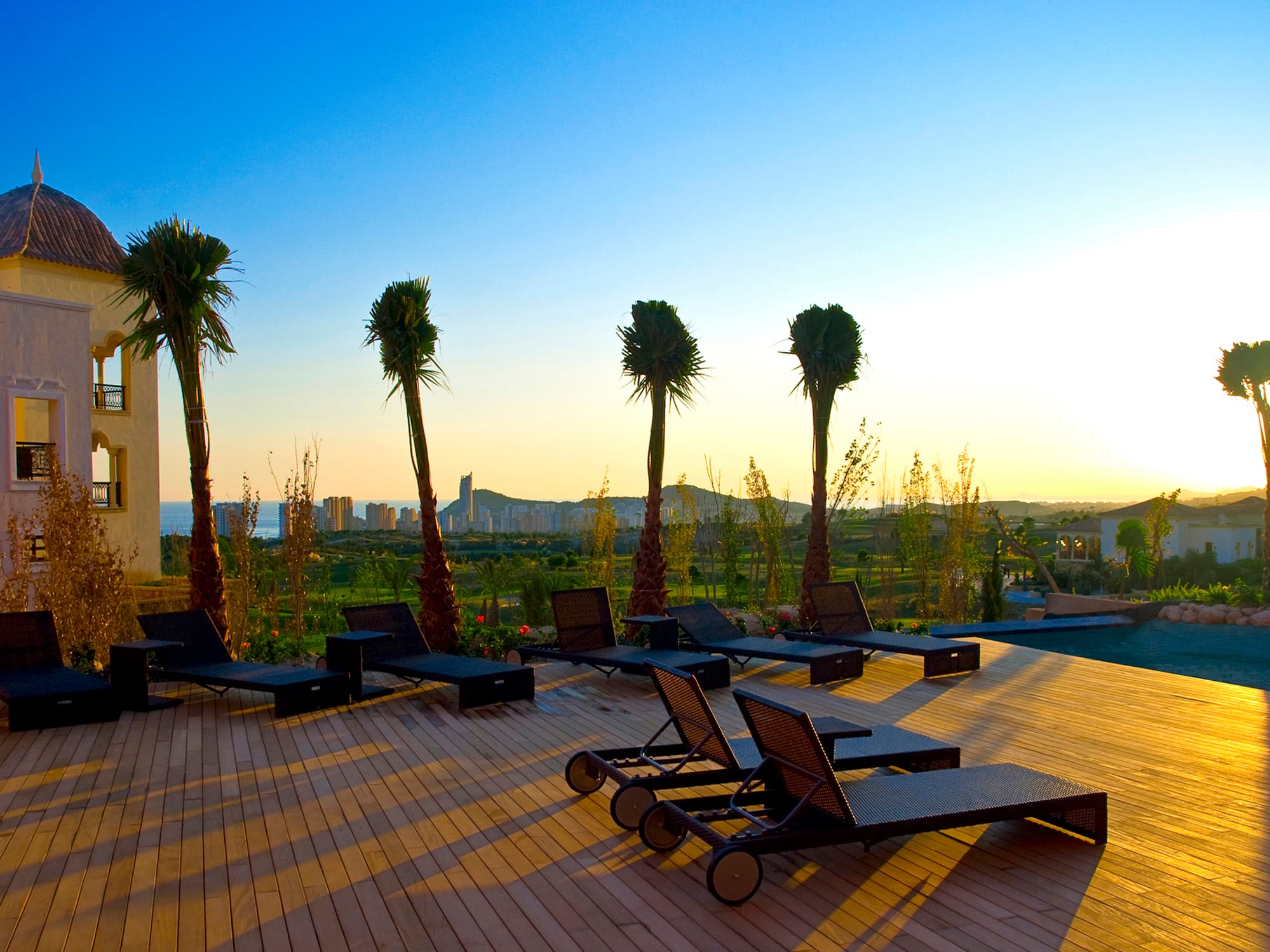 a deck with lounge chairs and palm trees
