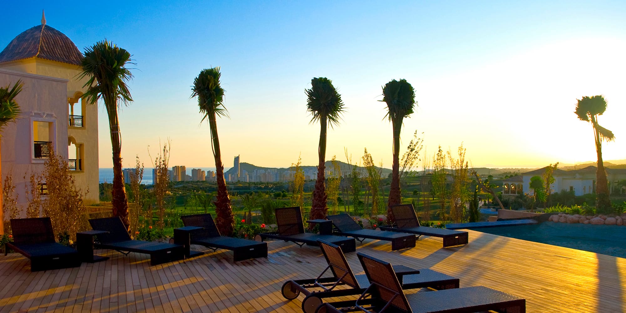 a deck with lounge chairs and palm trees