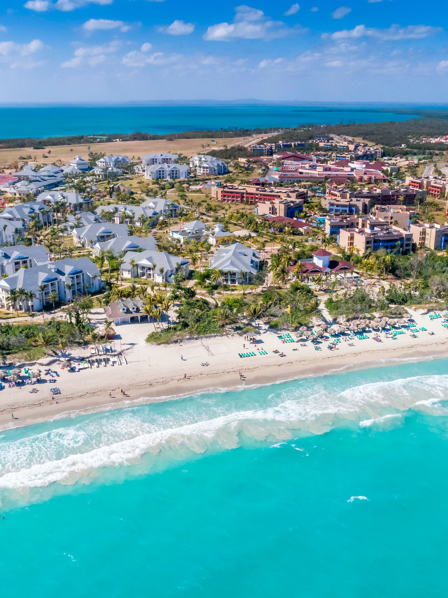 a beach with buildings and a body of water
