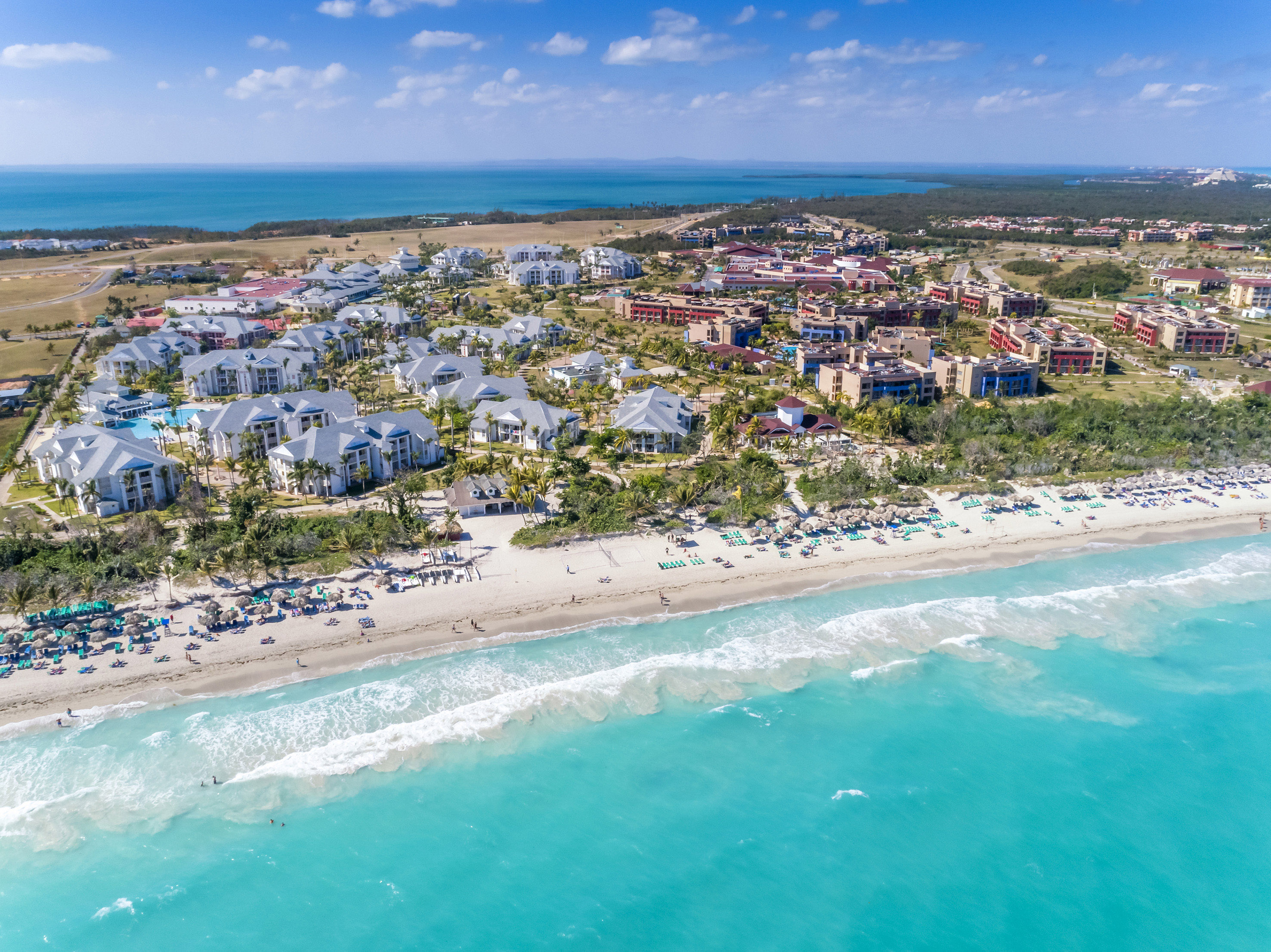 a beach with buildings and a body of water