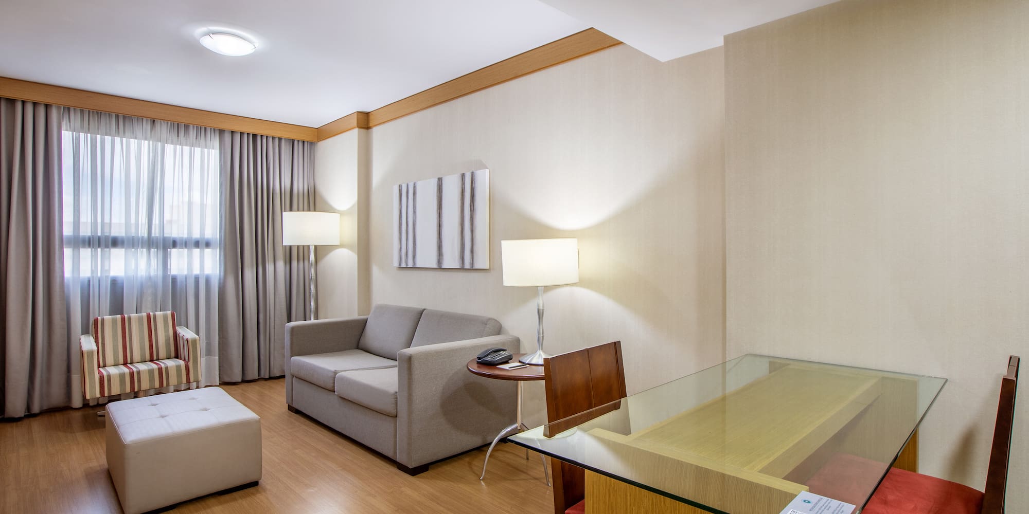 a room with a glass table and couches