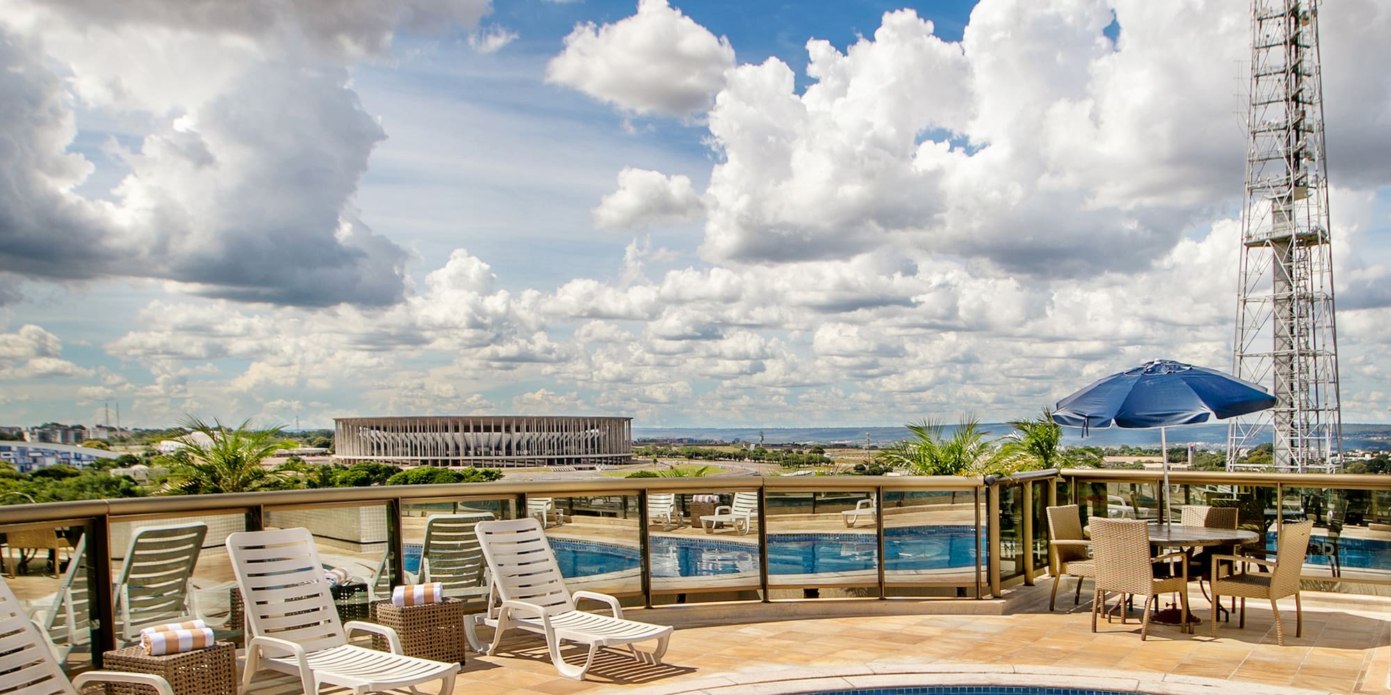 a pool with chairs and a tower in the background