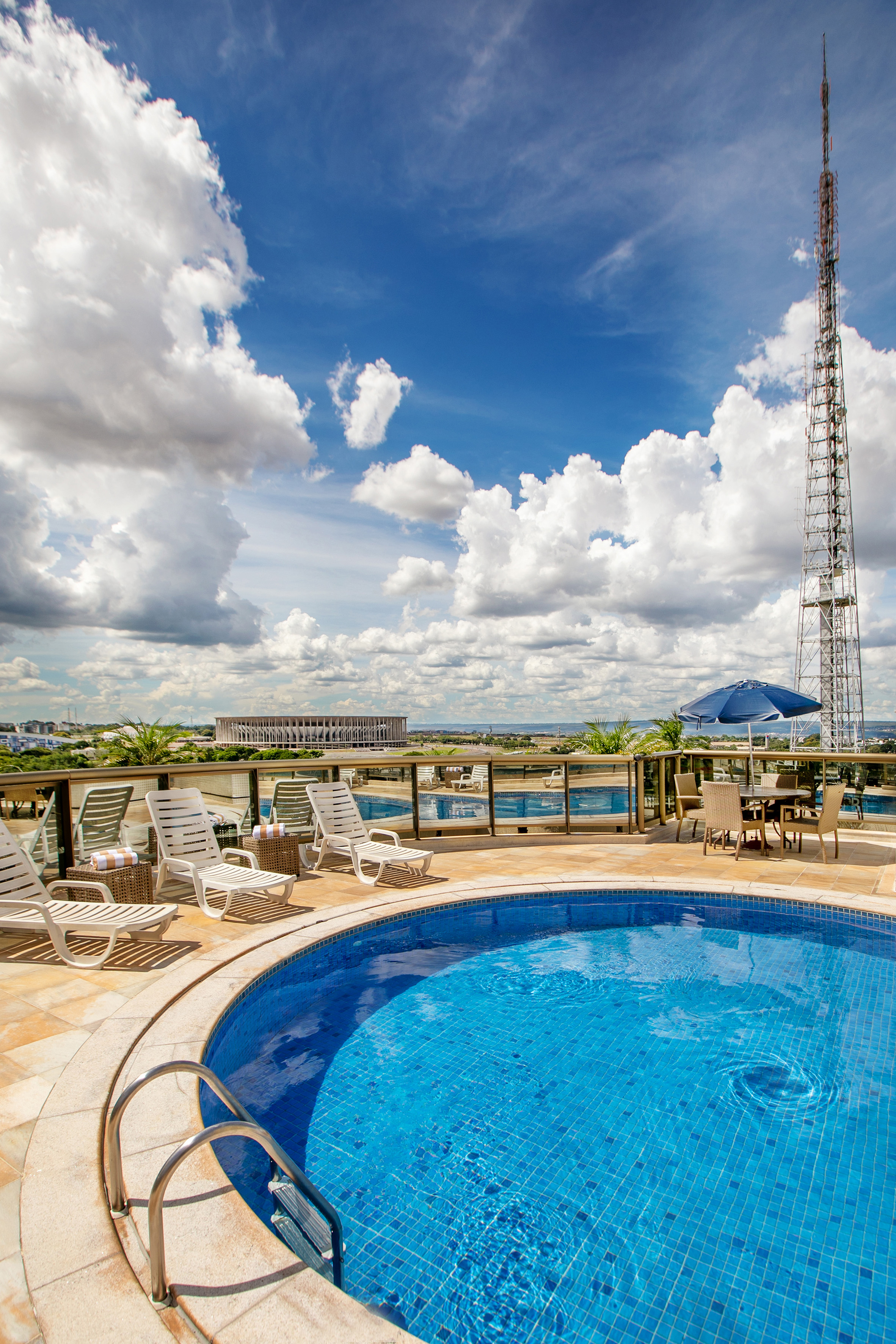 a pool with chairs and a tower in the background