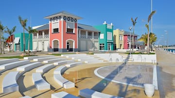 a row of colorful buildings with a fountain in front of them