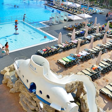 a pool with a boat shaped object and people around it