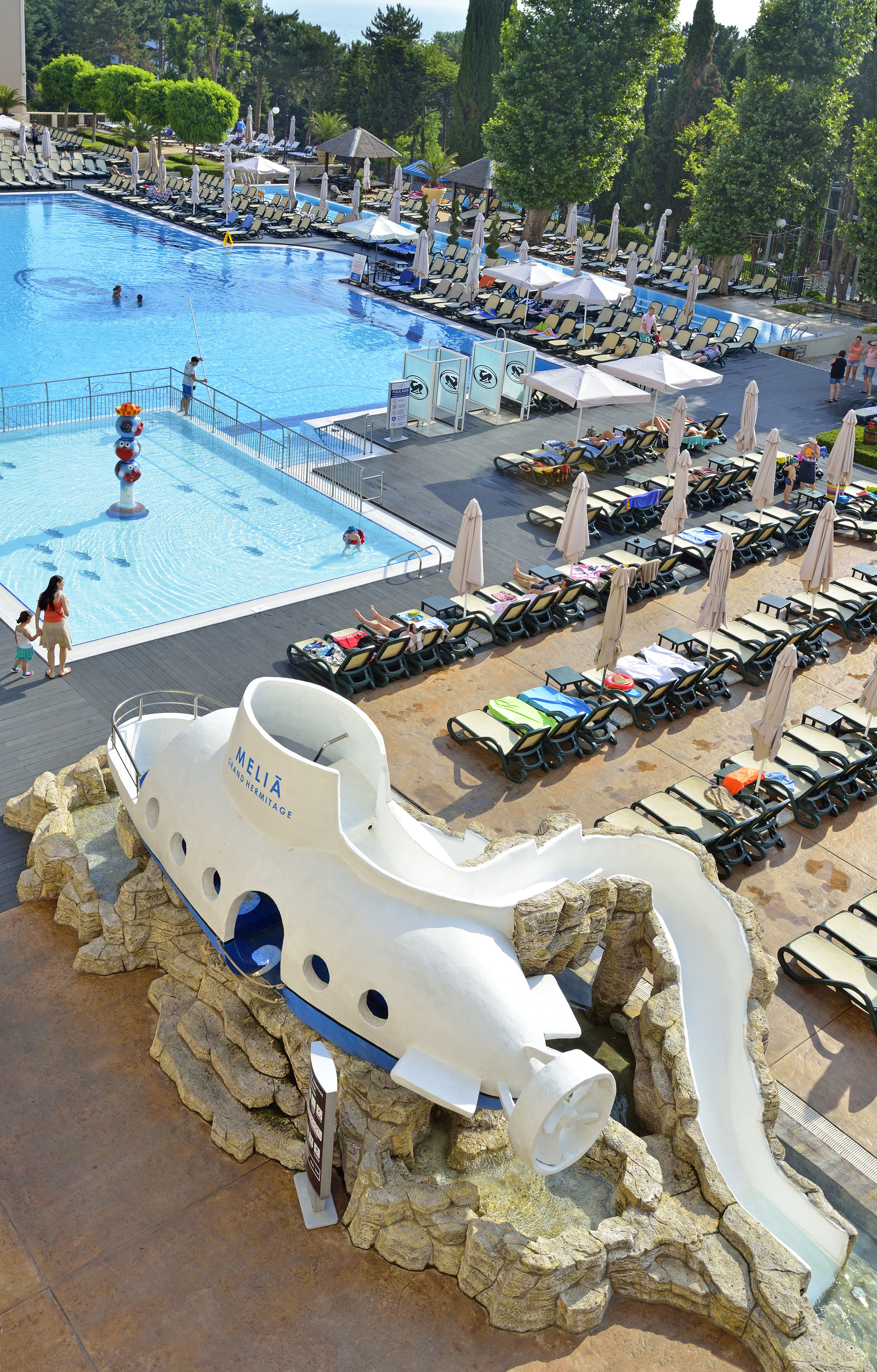 a pool with a boat shaped object and people around it