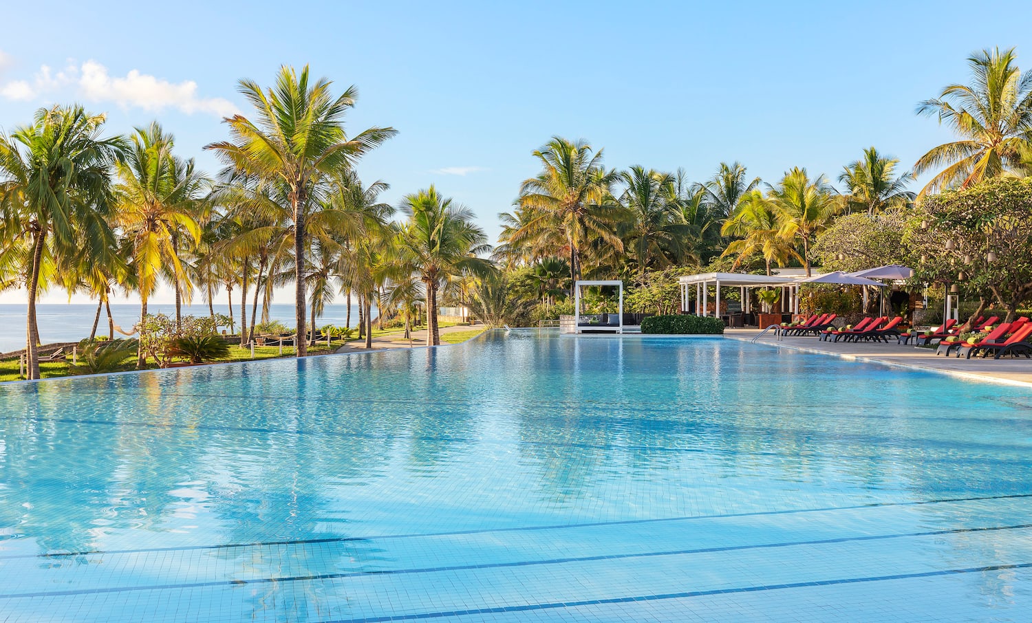 a pool with palm trees and a gazebo