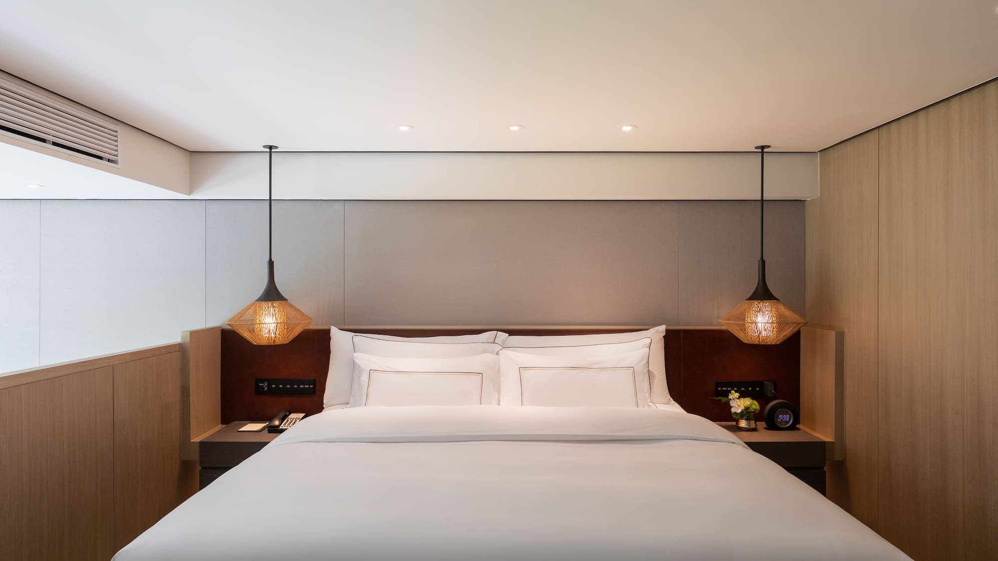 a bed with white sheets and lamps