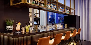 a bar with a row of chairs and drinks