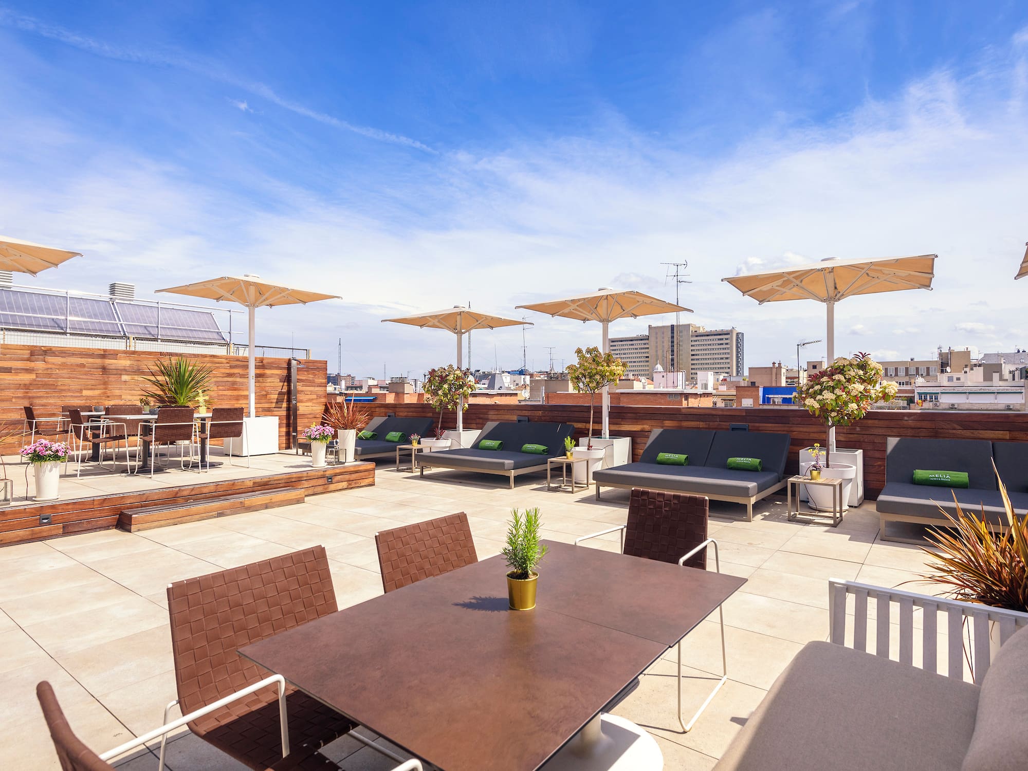 a patio with chairs and tables on a rooftop