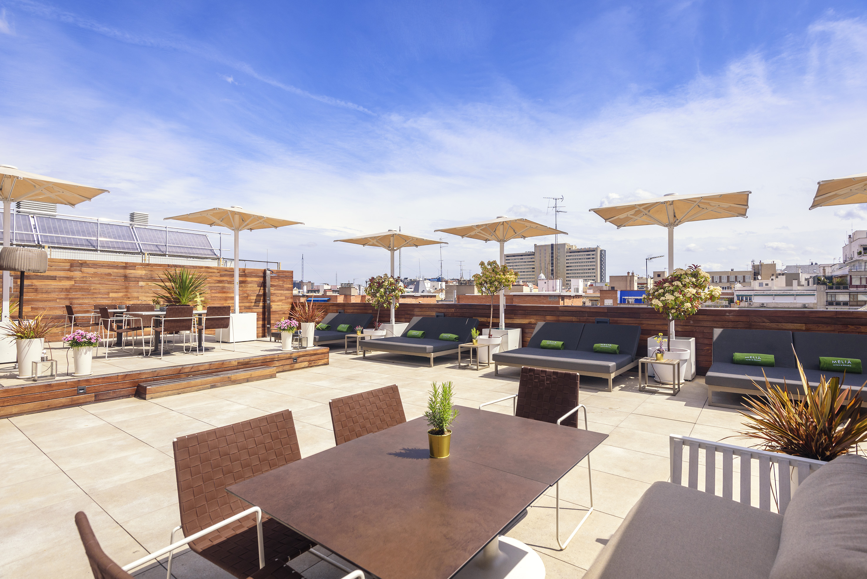 a patio with chairs and tables on a rooftop