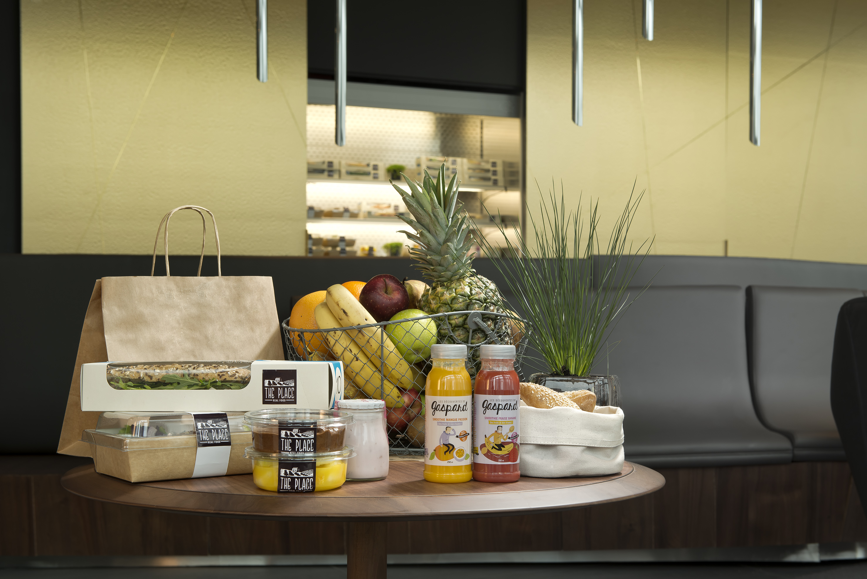 "The Place" takeaway meals, fresh fruit, and Gaspard smoothies on a cafe table.