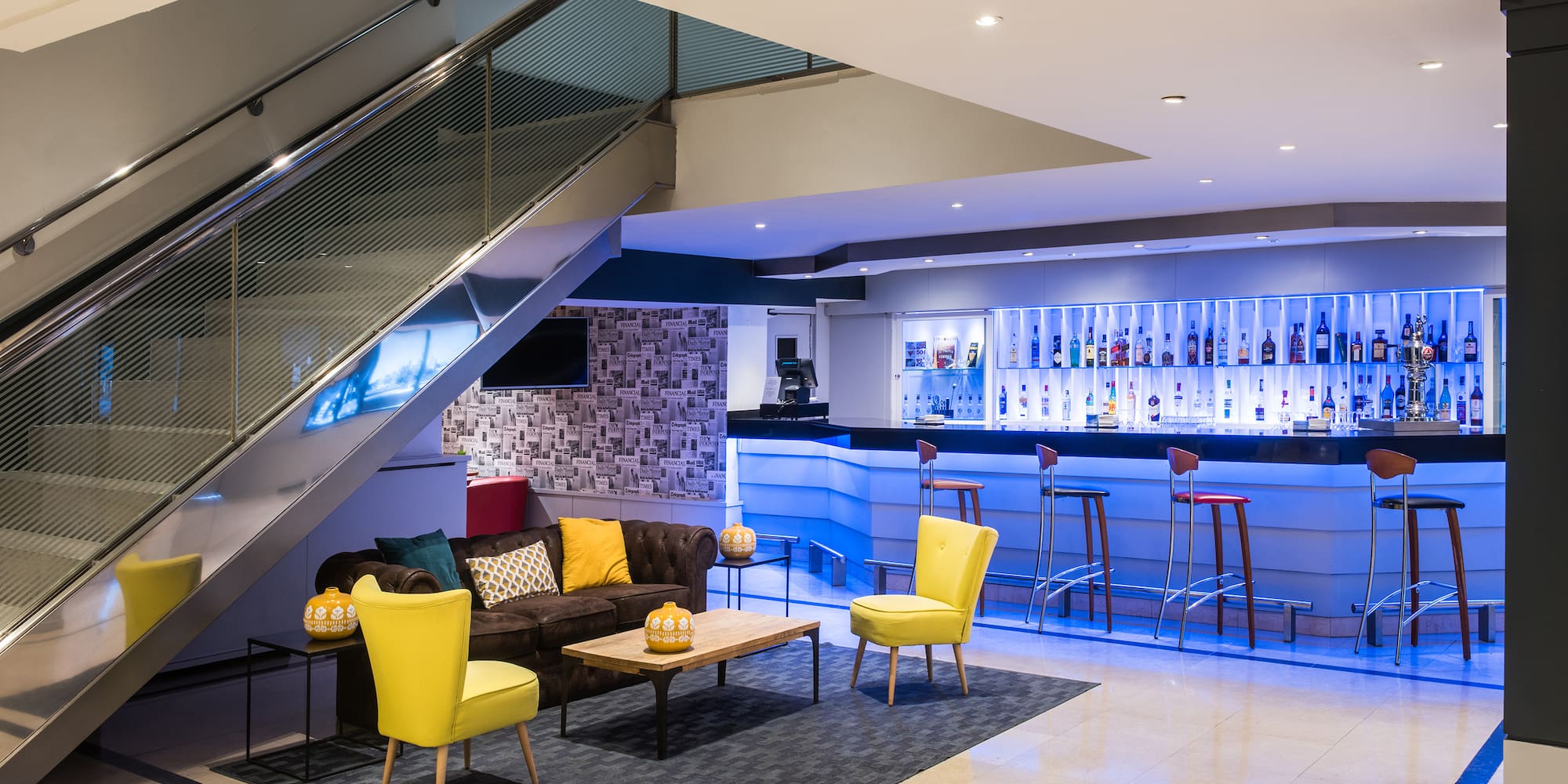 a room with a staircase and a couch and chairs