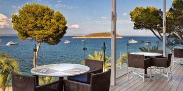 a table and chairs on a deck overlooking a body of water