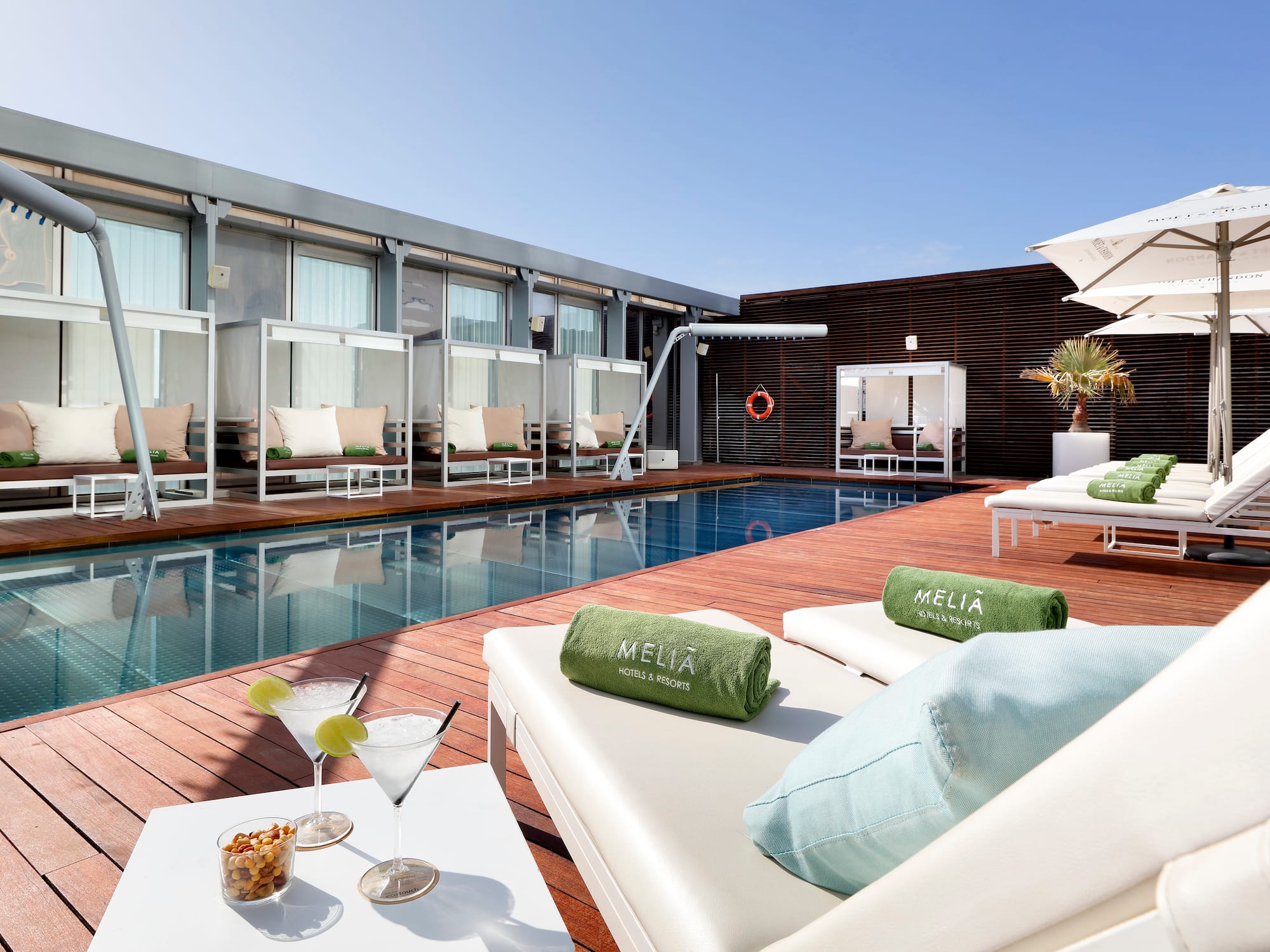 a pool with drinks and lounge chairs