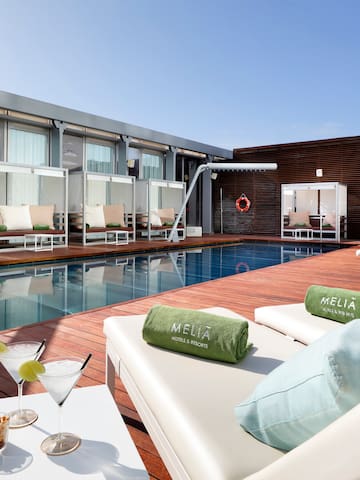 a pool with drinks and lounge chairs