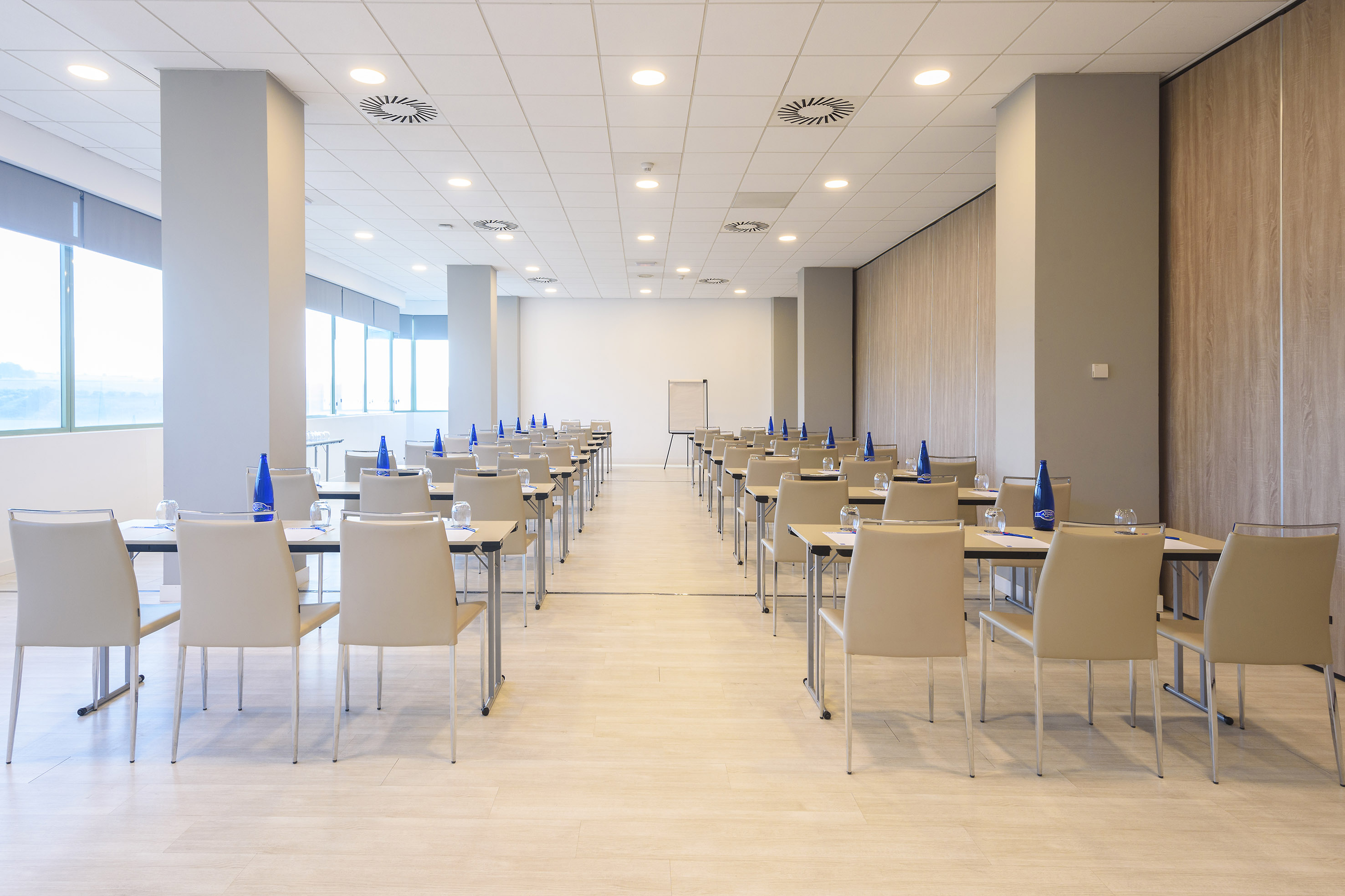 Empty modern conference room with tables, chairs, and whiteboard.