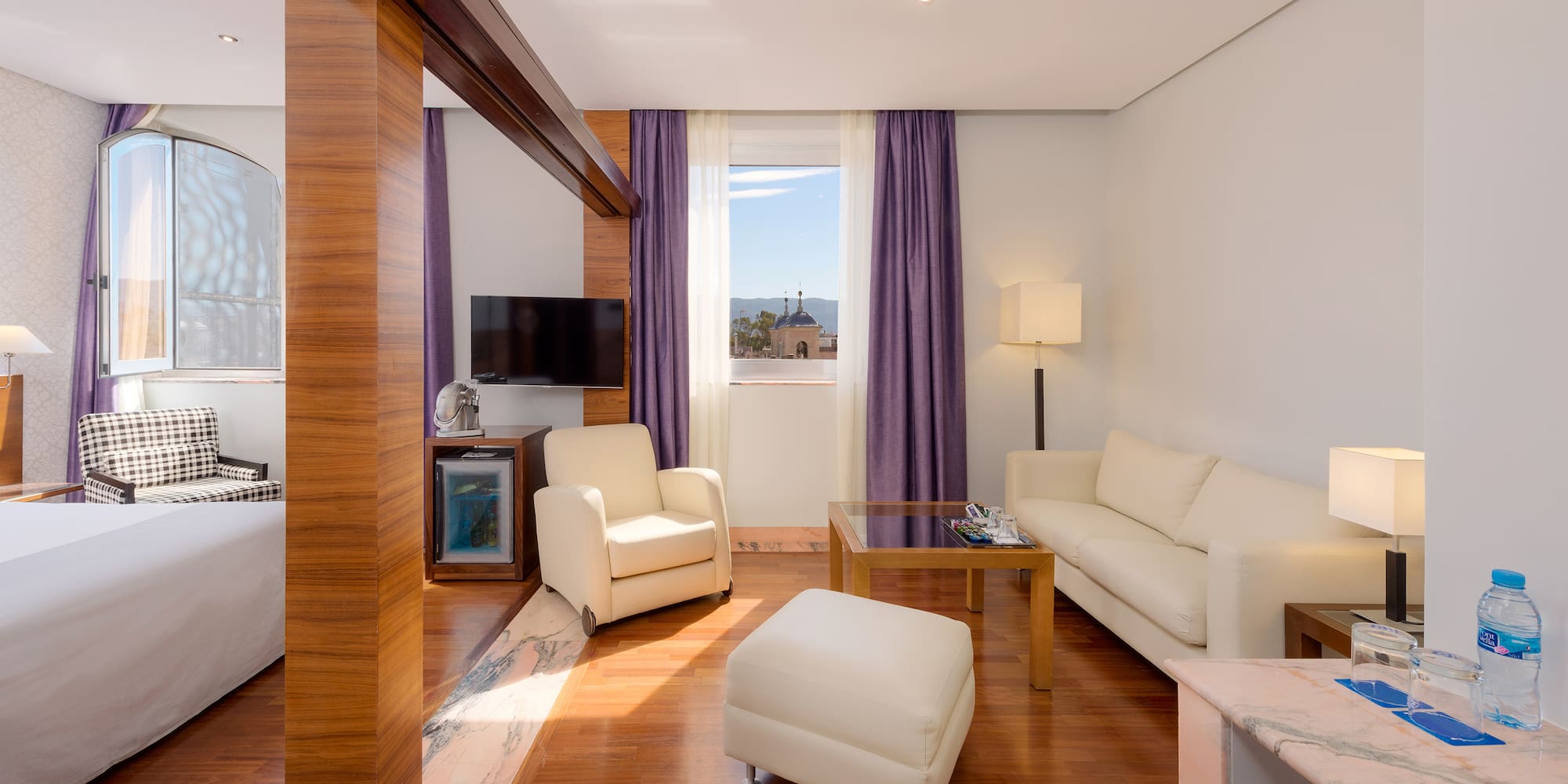 a room with white furniture and purple curtains