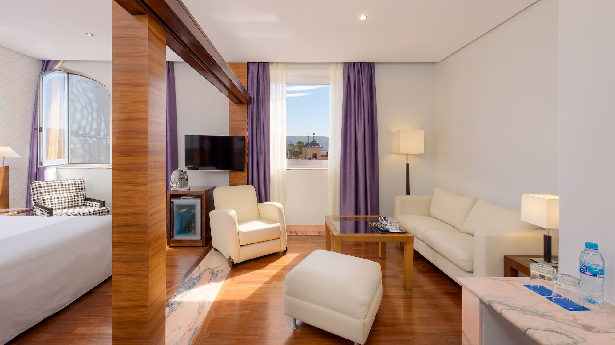 a room with white furniture and purple curtains