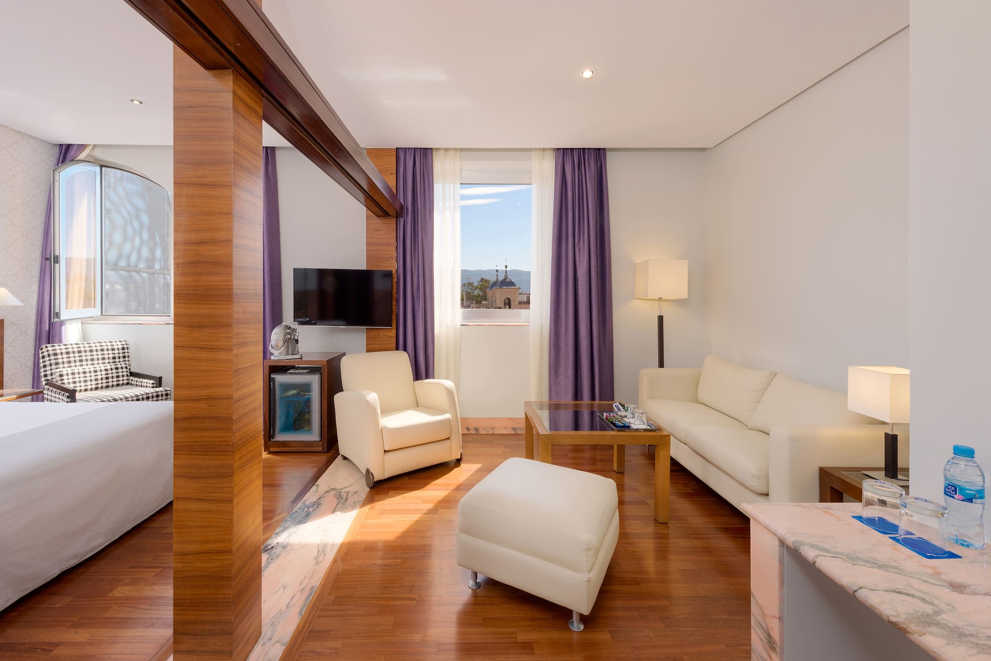 a room with white furniture and purple curtains