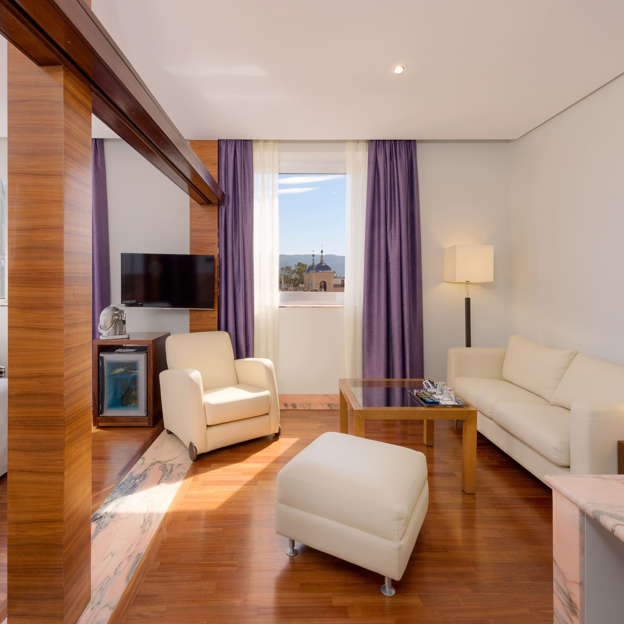 a room with white furniture and purple curtains