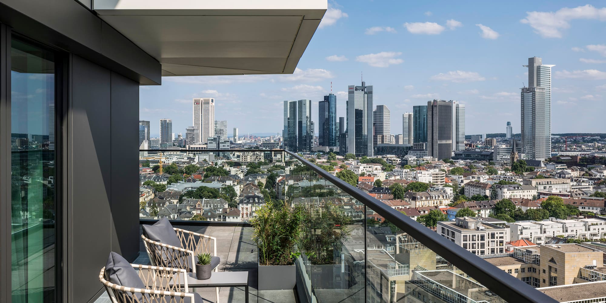 a balcony with a view of a city and a blue sky