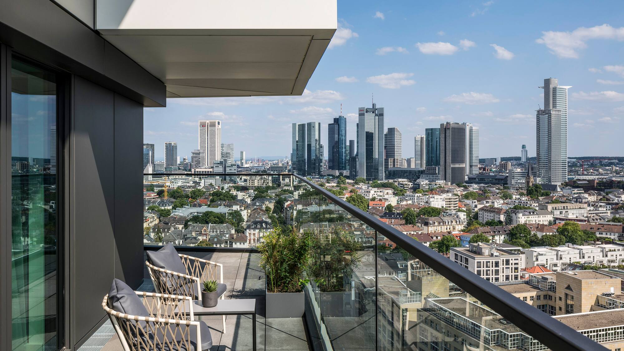 a balcony with a view of a city and a blue sky