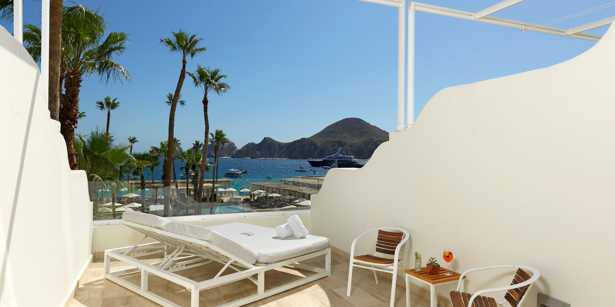 a white deck chair and table with chairs and a table on a sunny day