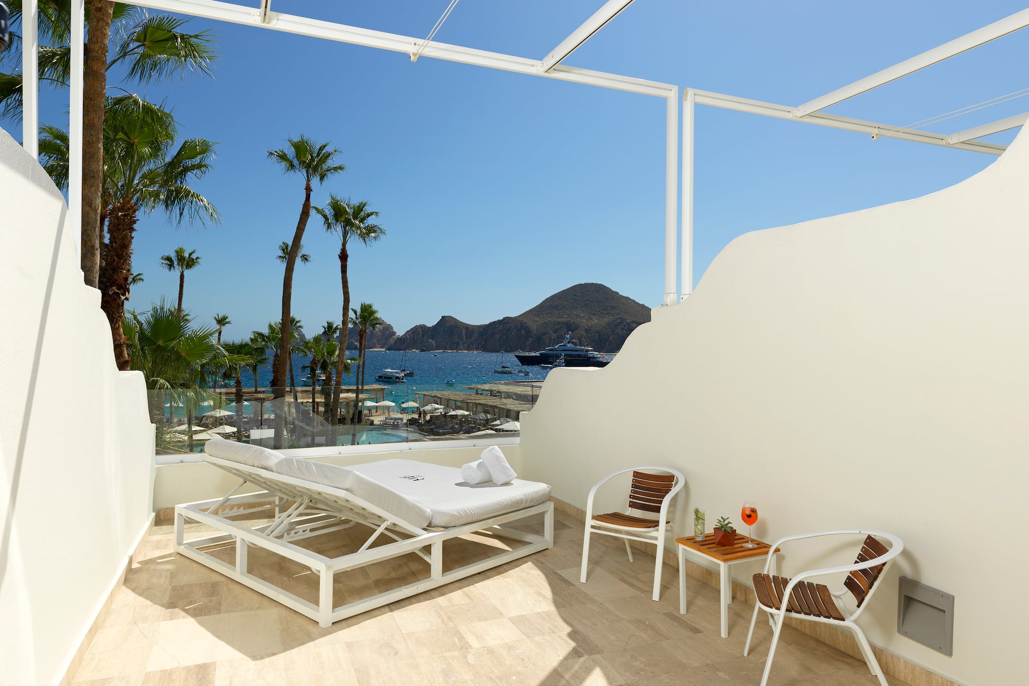 a white deck chair and table with chairs and a table on a sunny day