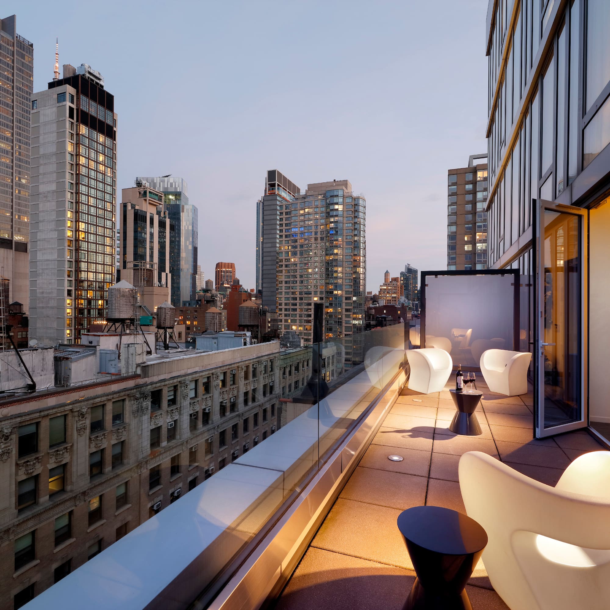 a balcony with chairs and tables in a city