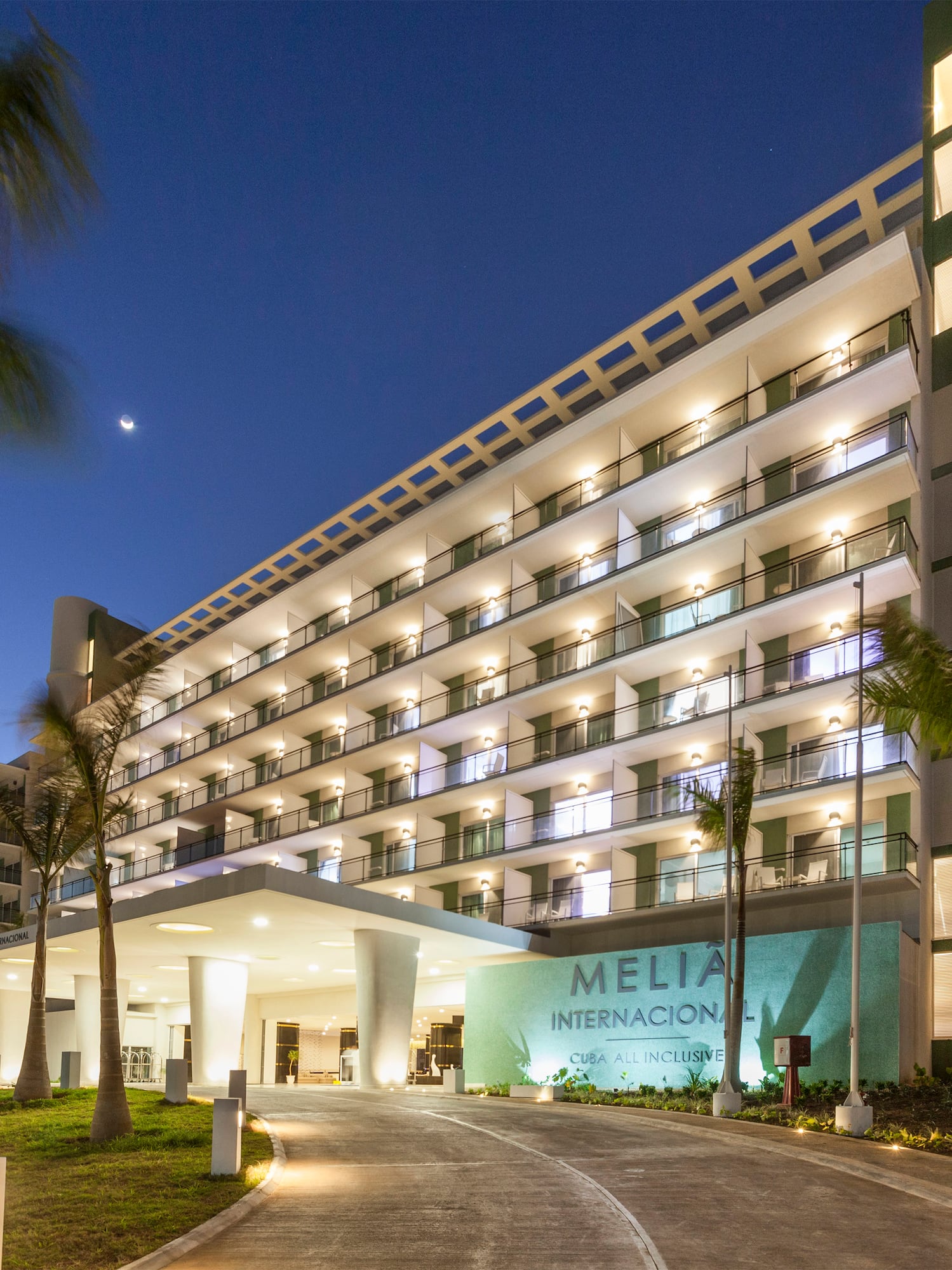 a building with palm trees and a walkway