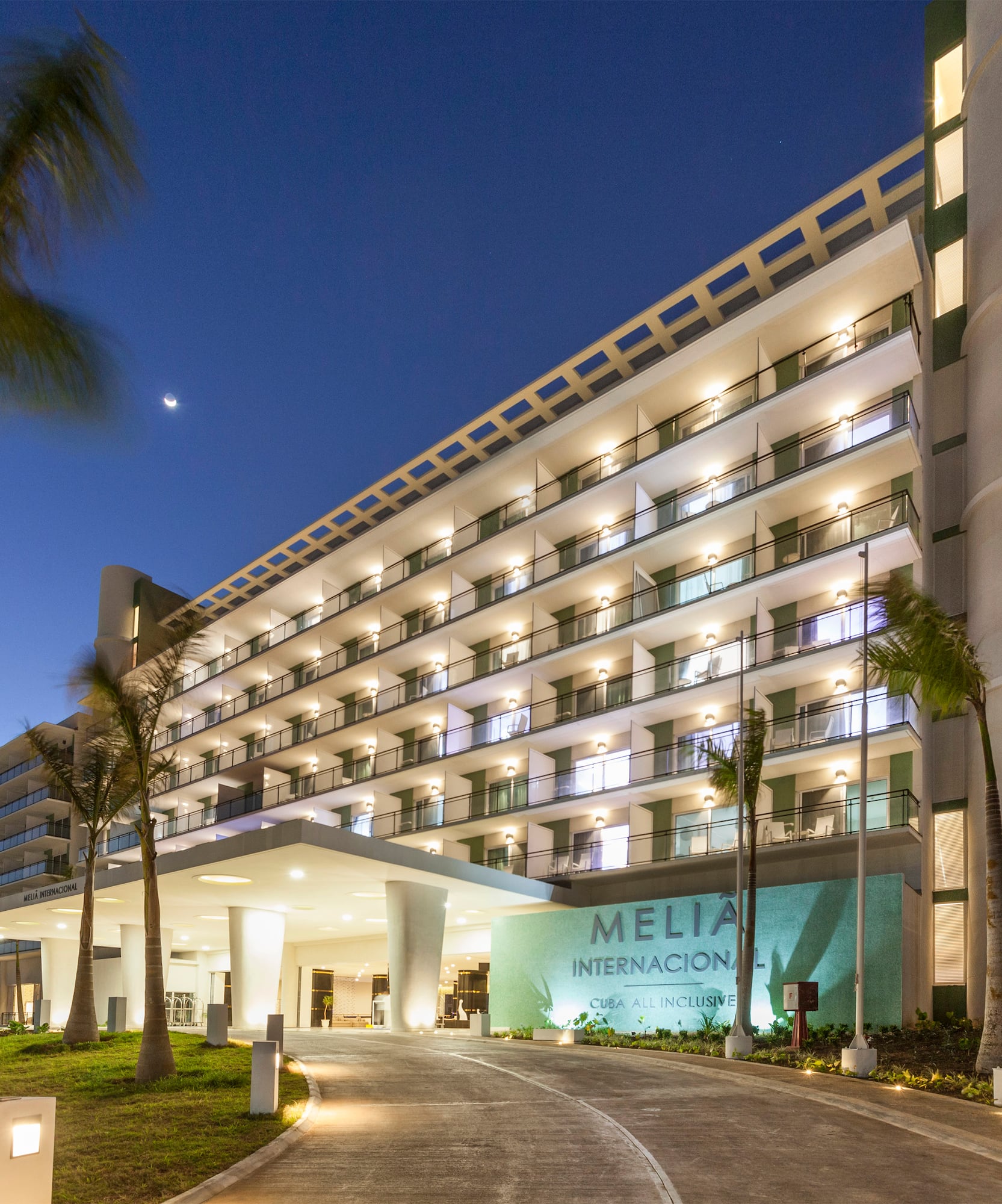 a building with palm trees and a walkway