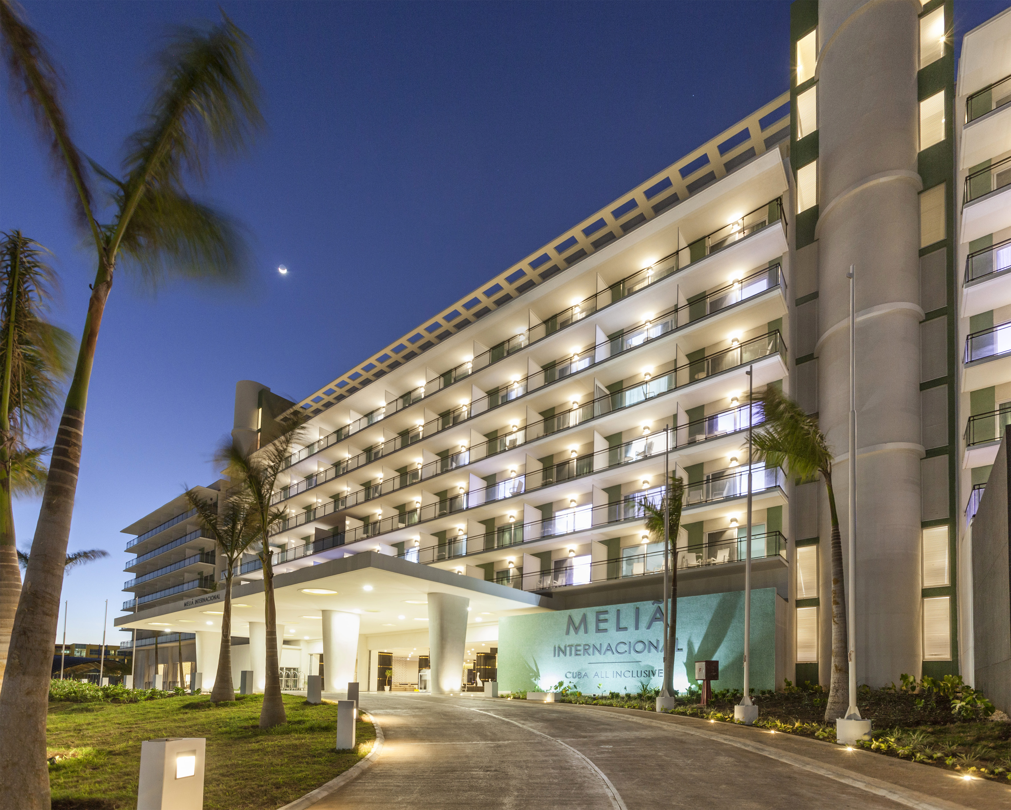a building with palm trees and a walkway